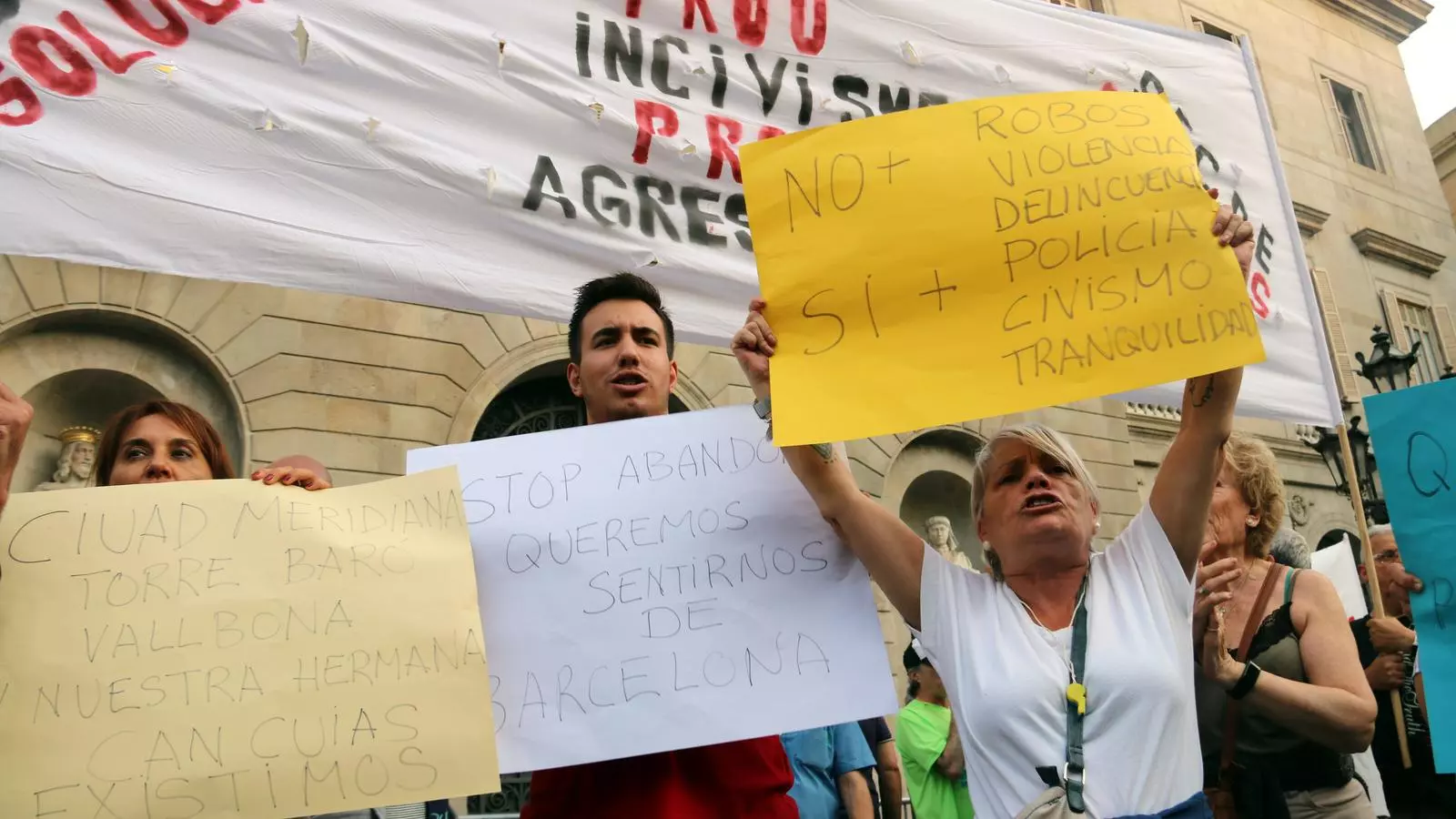Uns manifestants amb pancartes a les portes de l'Ajuntament de Barcelona