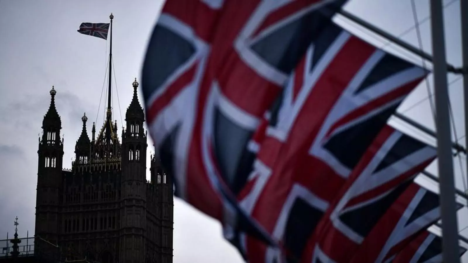 La Union Jack en primer terme, sobre una de les torres del palau de Westminster al fons.