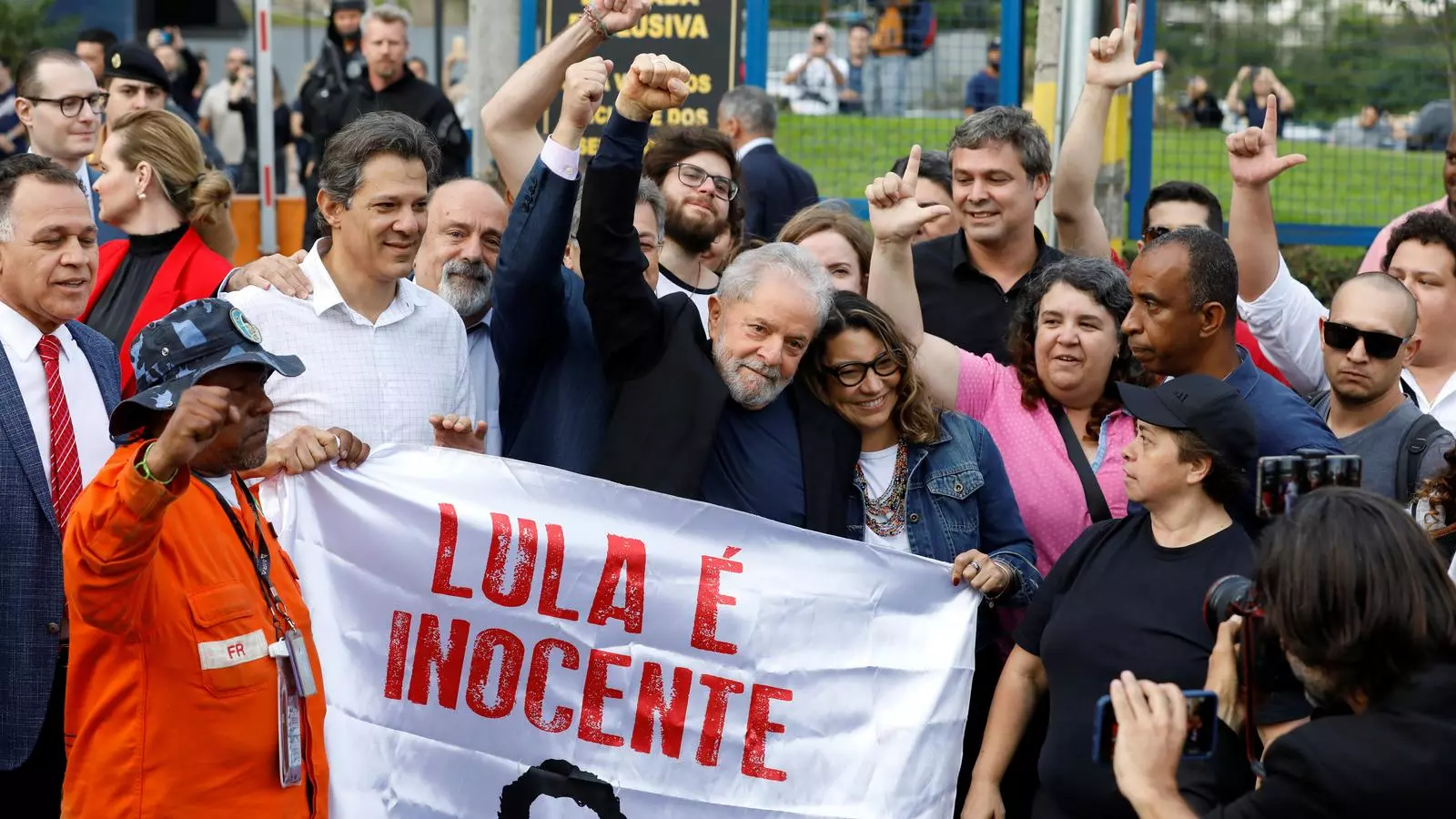 Lula alçant la mà dreta, envoltat de seguidors que l'han esperat a la sortida de la presó de Curitiba
