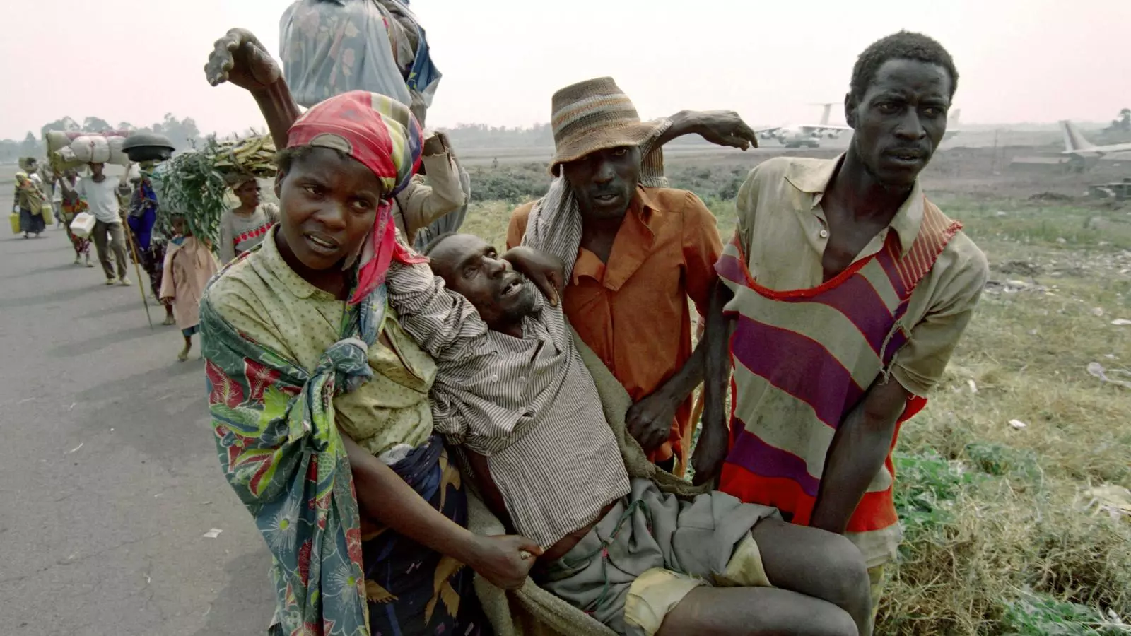 Refugiats ruandesos carreguen un familiar, esgotat i famolenc, fins un camp de refugiats situat a prop de l'aeroport de Goma, República Democràtica del Congo, juliol 1994.