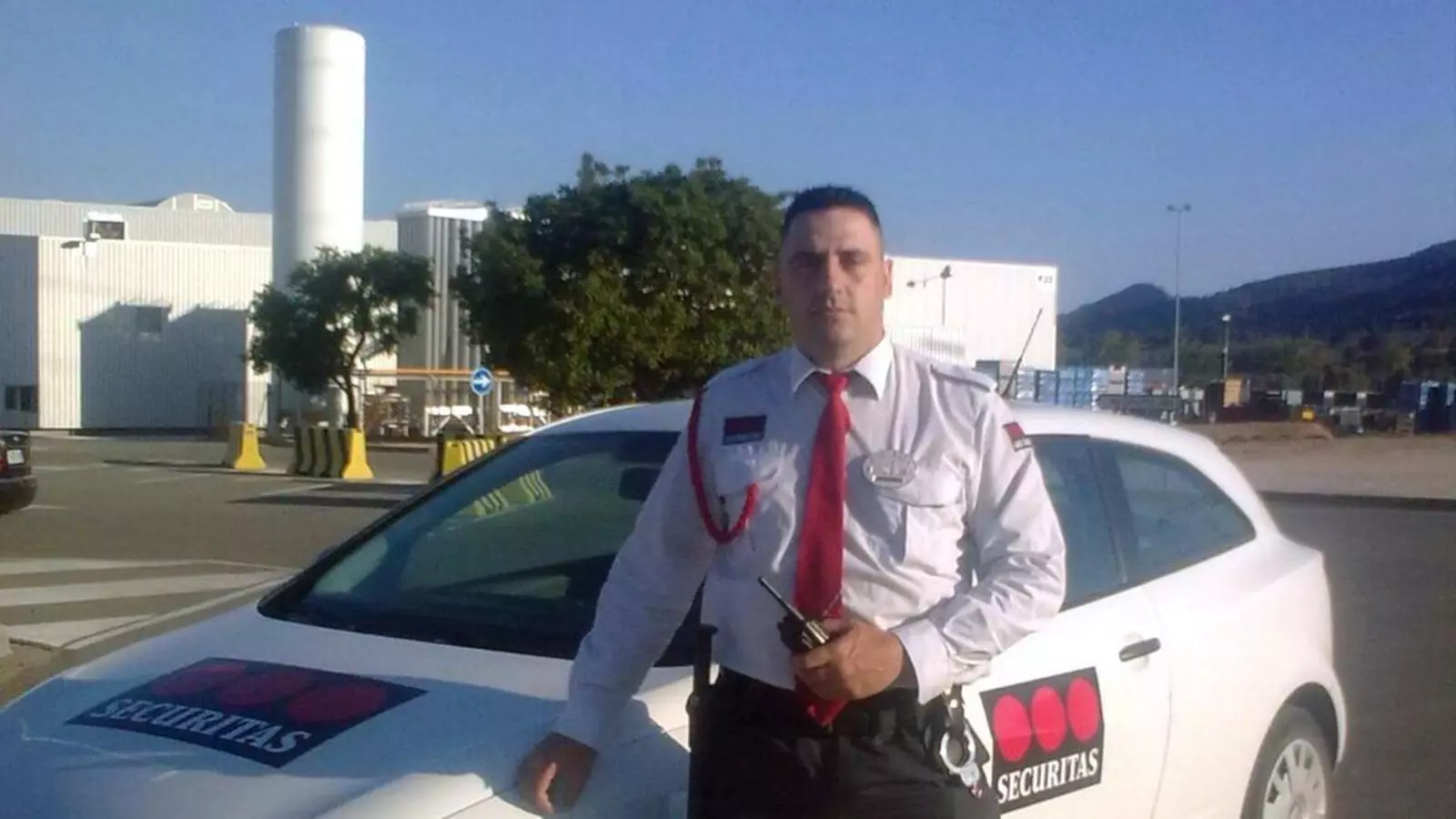 L'exvigilant de Securitas uniformat i davant d'un cotxe de l'empresa