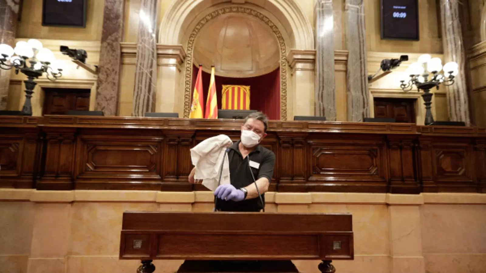 Un treballador del Parlament netejant el faristol aquest divendres