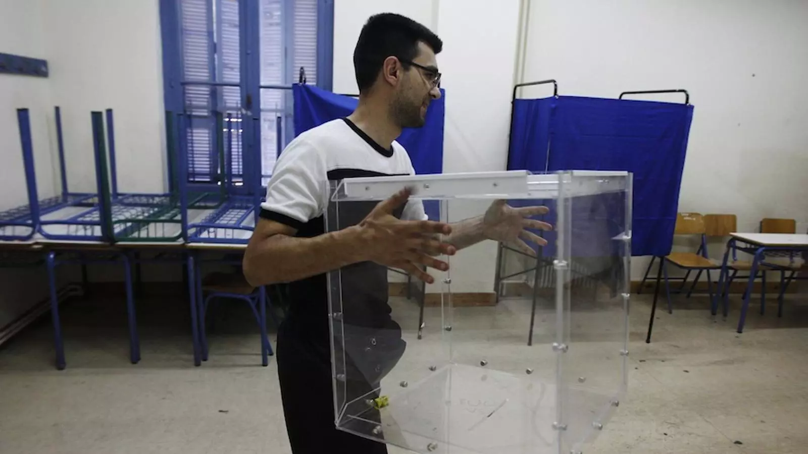 urnagr Un grec porta una urna a un centre de votació al centre d'Atenes. / JOHN KOLESIDIS (REUTERS)