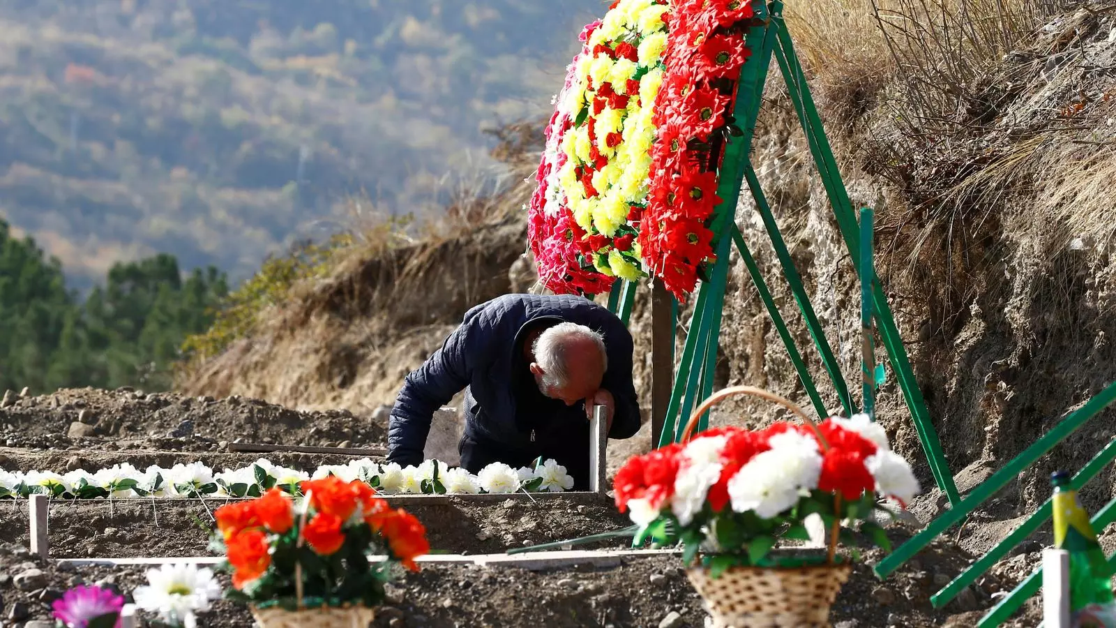 Un home plora sobre la tomba d'un soldat mort durant una batalla en el conflicte entre Armènia i l'Azerbaidjan.