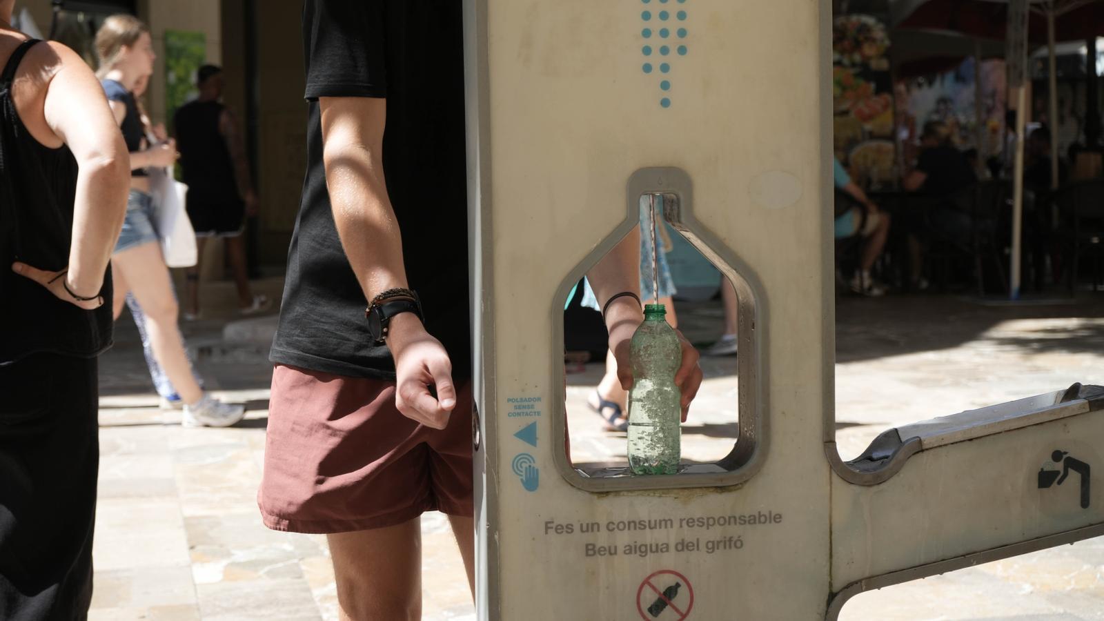A person fills a bottle of water.