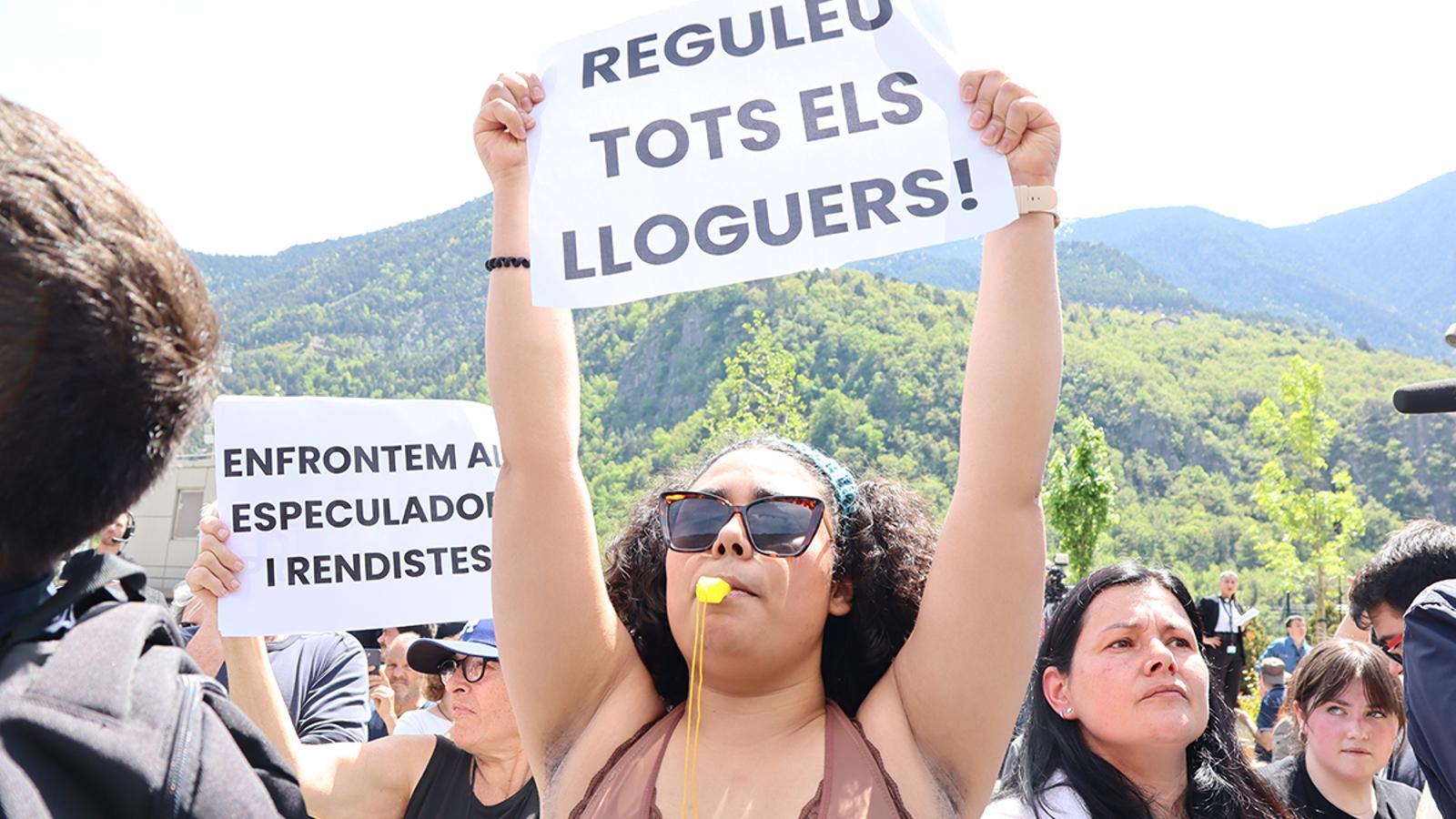 Una dona sosté una pancarta durant la protesta a la plaça del Poble.