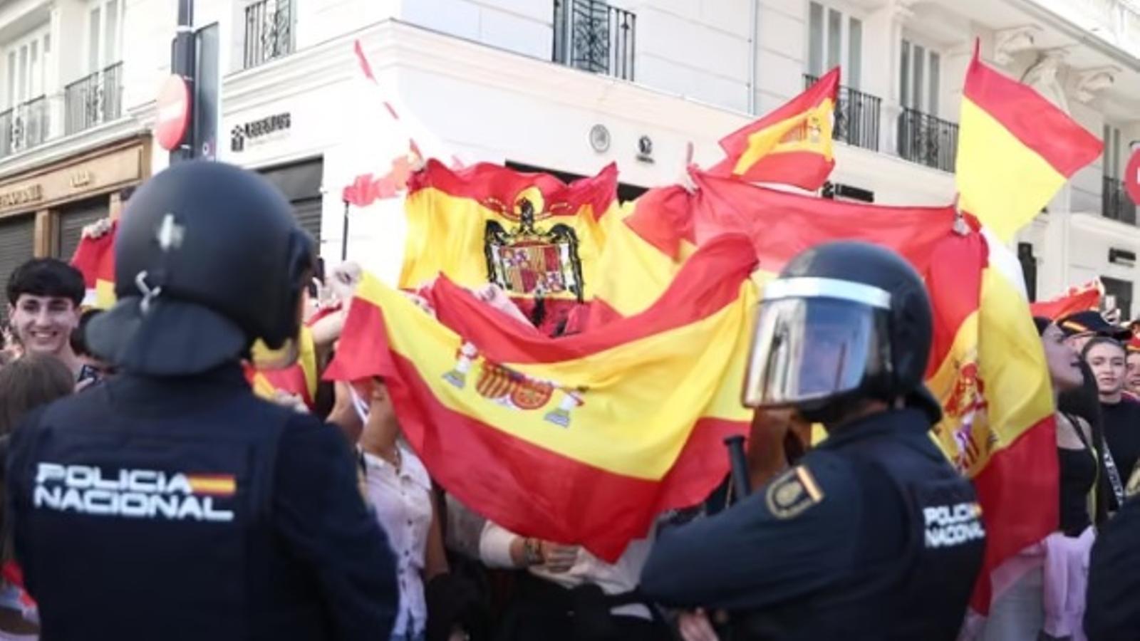 Several people with the flag of Spain rebuke those camped for housing at Puerta del Sol, on October 12, 2026, in Madrid.