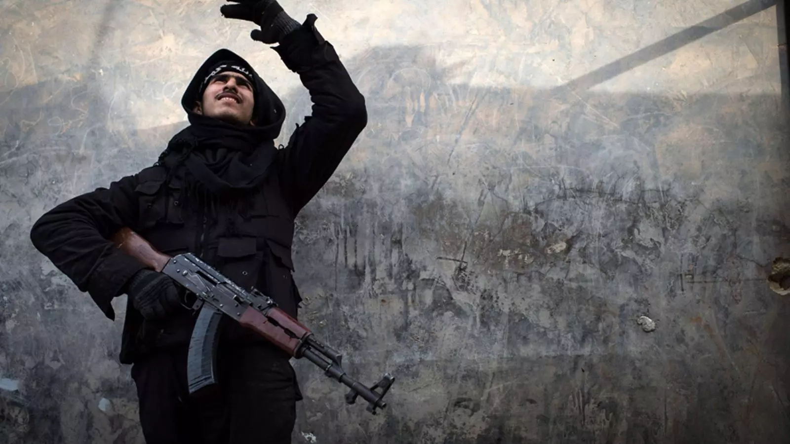 Un combatent rebel intenta localitzar un avió de combat del govern a la ciutat d'Alep, Síria / AFP/ Elias Edouard