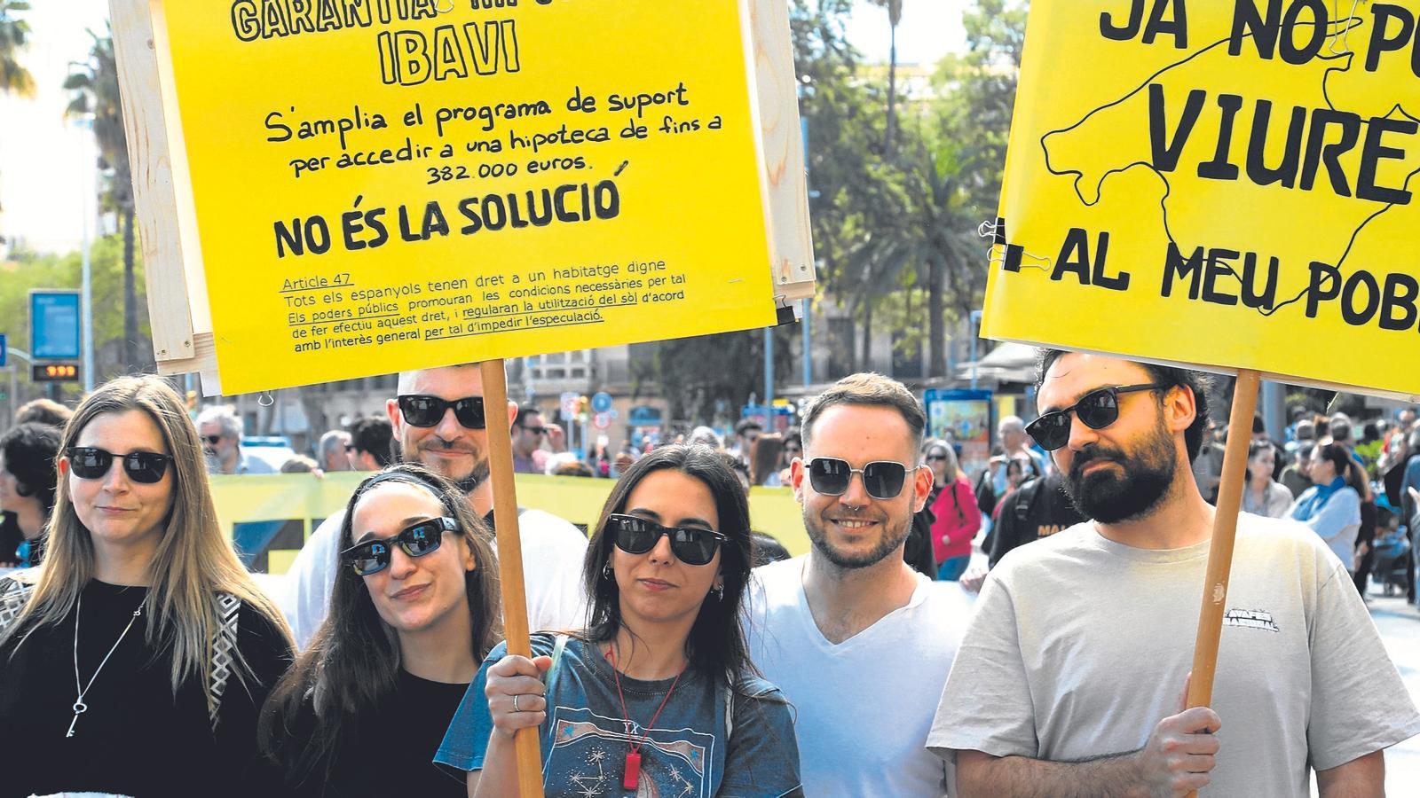 Attendees at the Palma demonstration against overcrowding hold signs denouncing the housing problem.