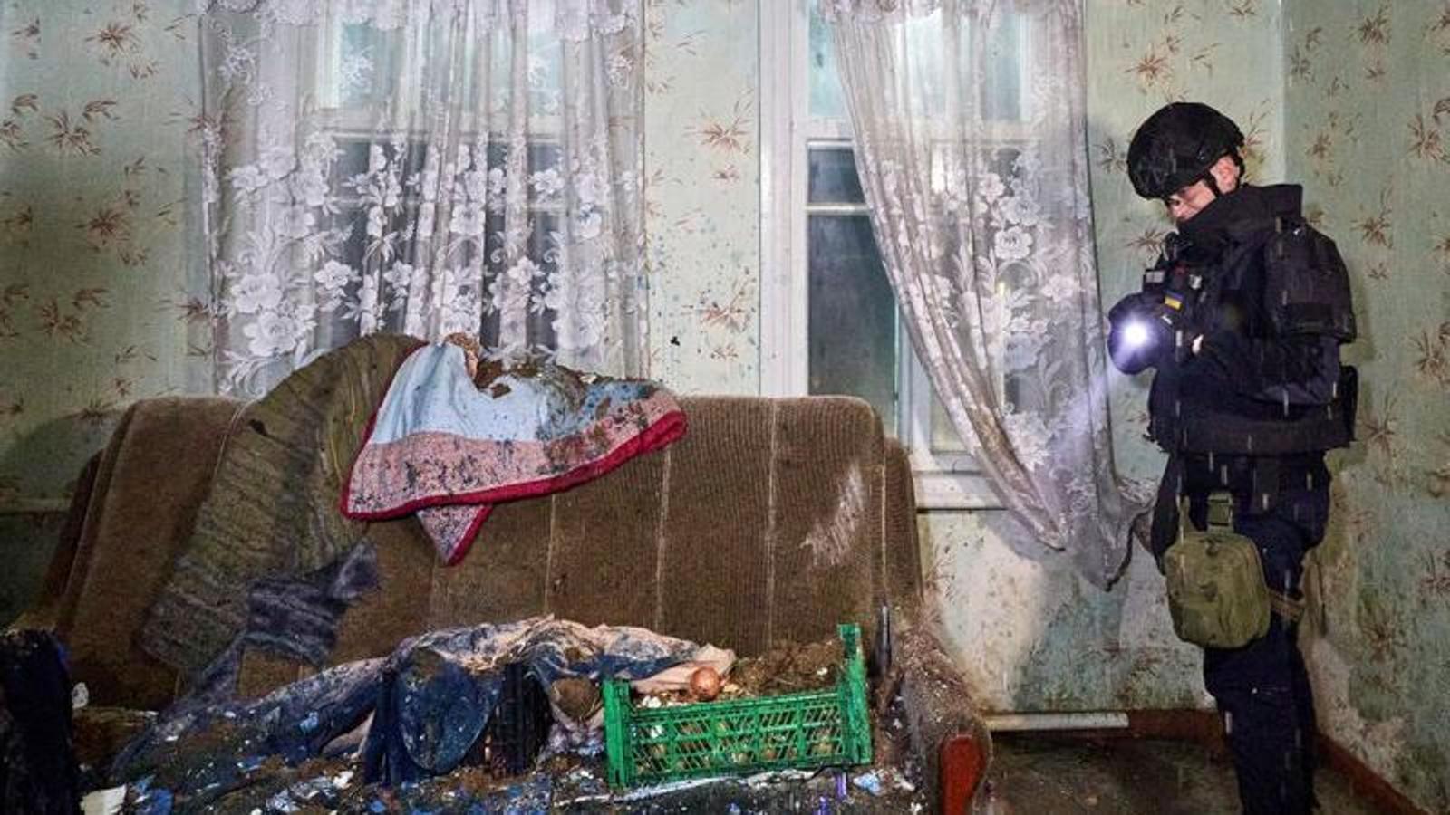 Un policia ucraïnès inspecciona els danys a una habitació després del bombardeig d'un 'dron' rus a Khàrkiv.