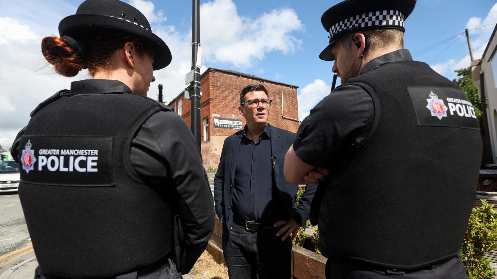 The Mayor of Greater Manchester and Labour candidate Andy Burnham speaks with local police officers, as part of a campaign event ahead of this Thursday's Makerfield by-election.
