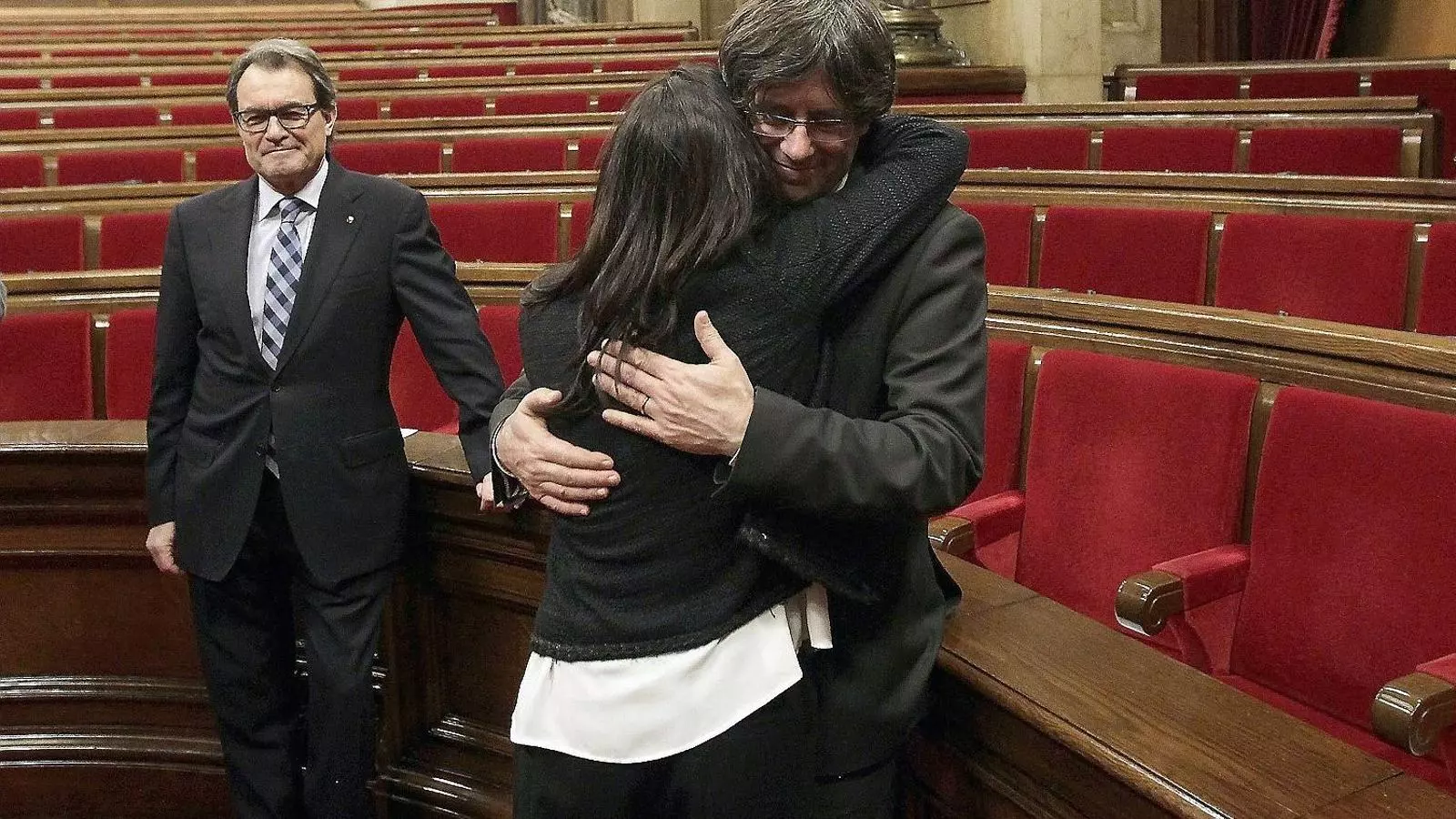 El president Puigdemont abraçant-se ahir amb la seva esposa, Marcela Topor, sota la mirada del president sortint, Artur Mas.