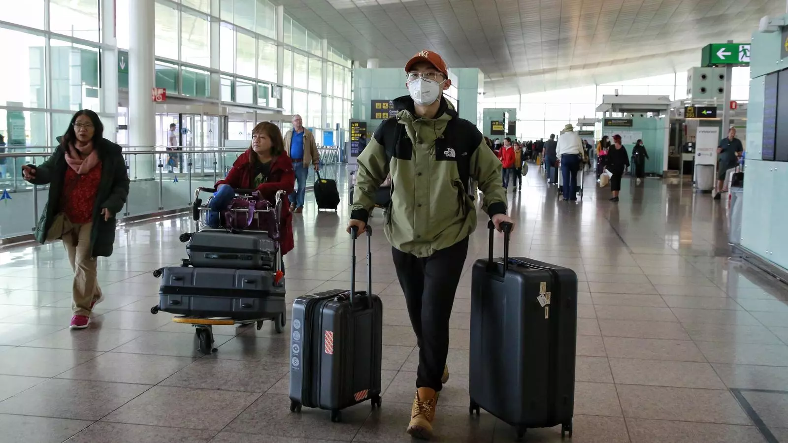 Viatgers, amb mascaretes pel coronavirus, a la terminal de sortides de l'aeroport del Prat, aquest matí