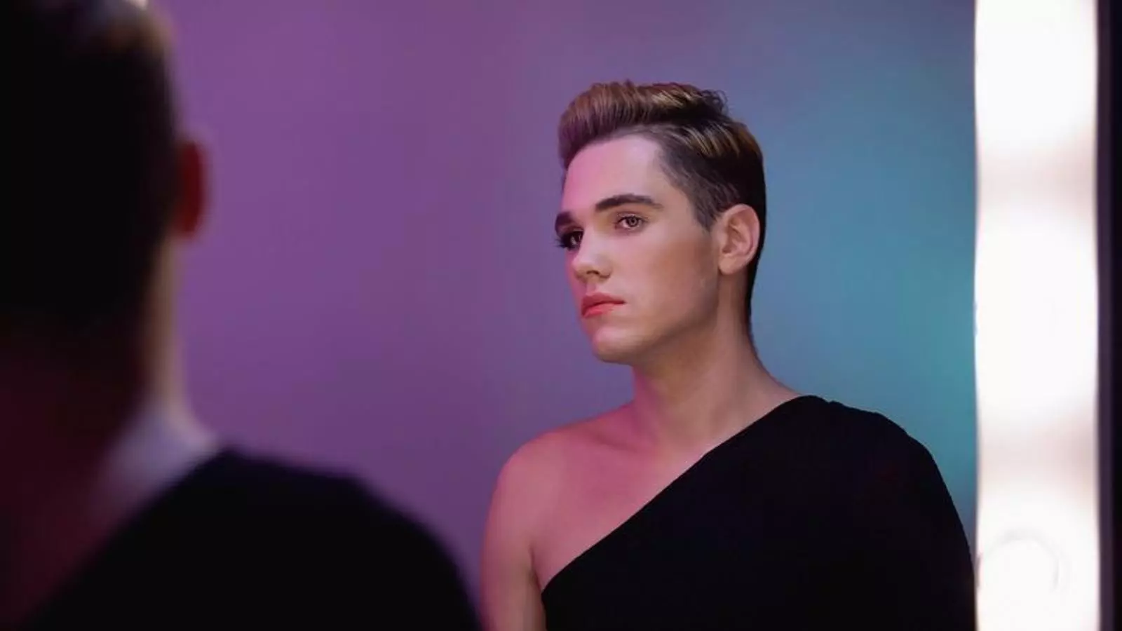 Una imatge d'un transsexual que es mira al mirall.