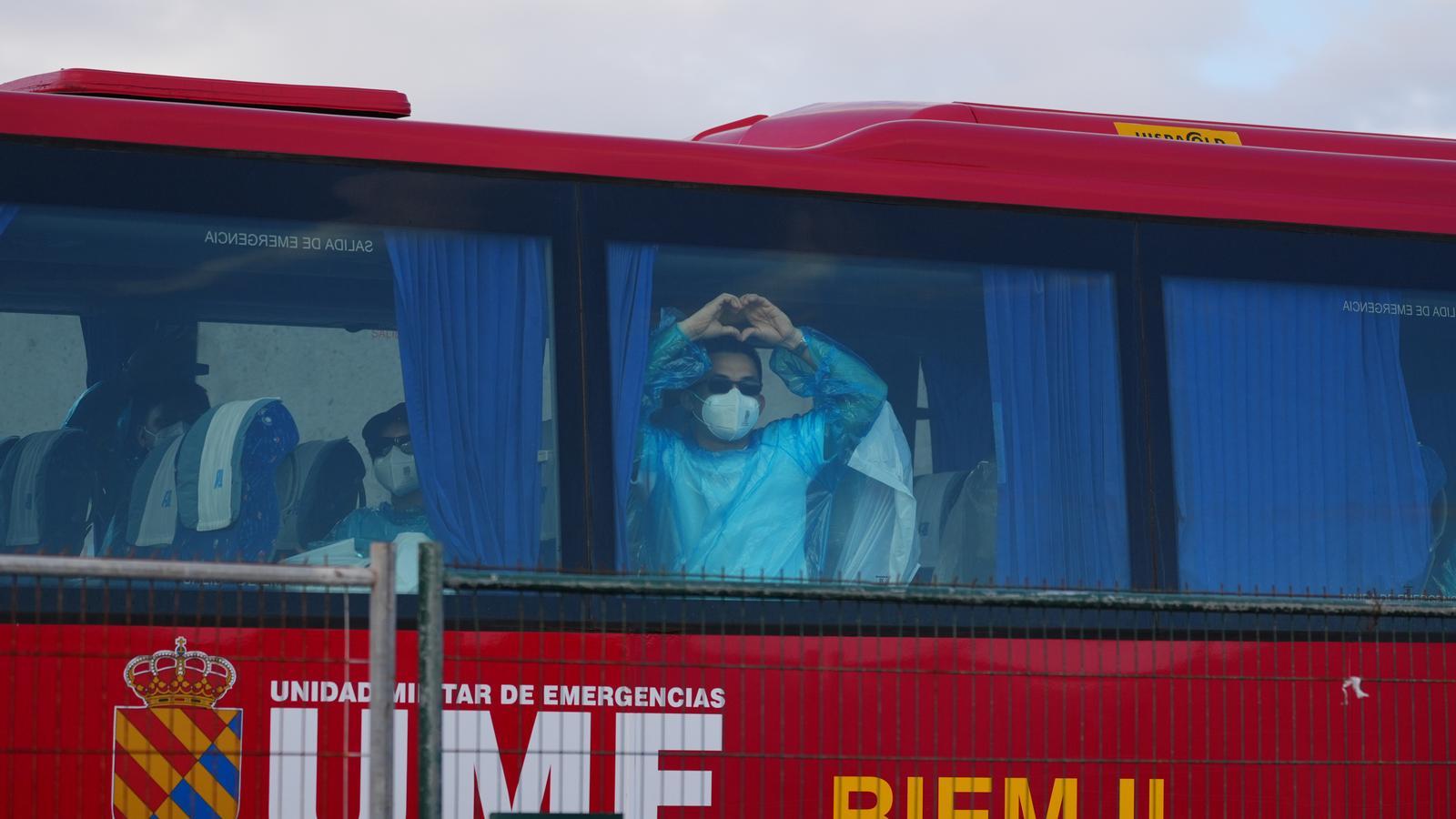 Un pasajero del crucero afectado por hantavirus hace el signo de corazón a bordo del autobús que lo transporta al aeropuerto.