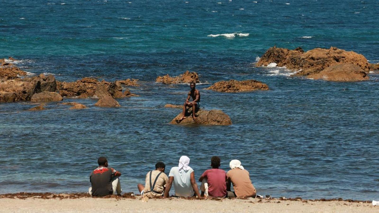 Migrants wait on the beach of Ceuta after massive attempts to enter from Morocco.