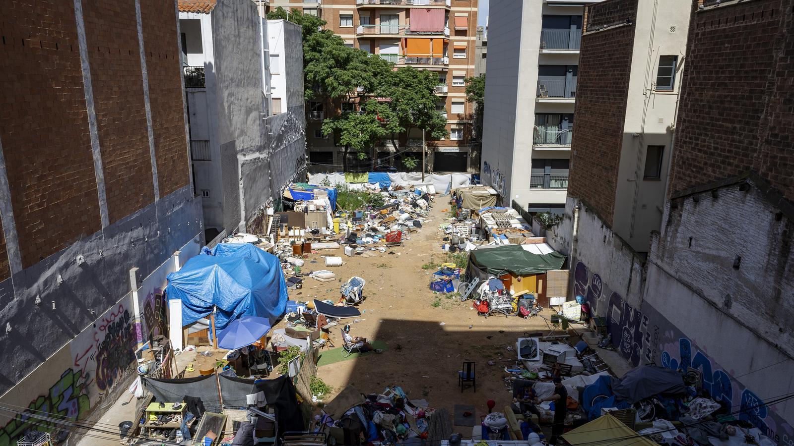 A settlement of shacks and tents survives amidst buildings on a plot of land in the Sant Andreu district, in Barcelona.