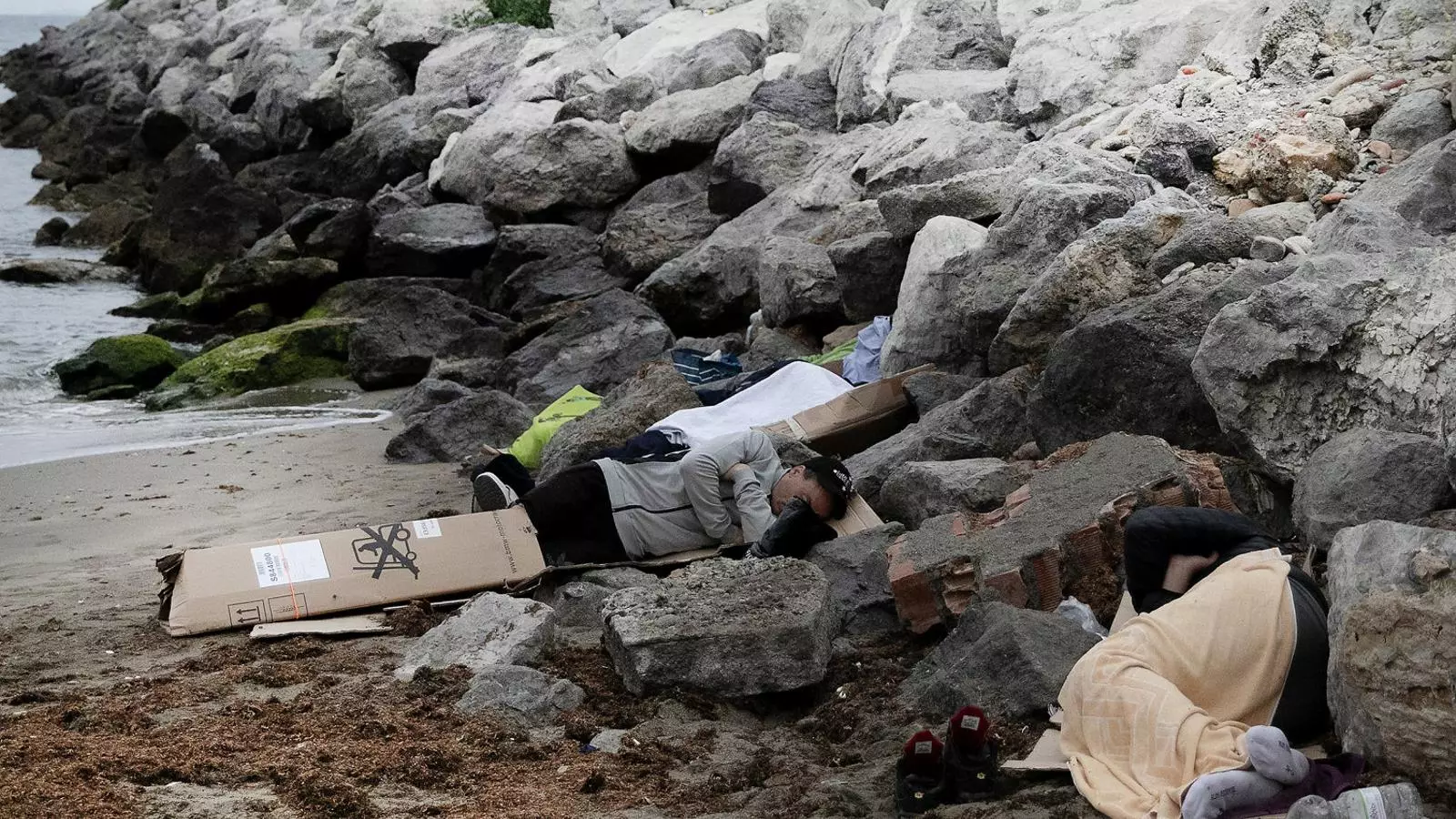 Joves marroquins que van entrar a Ceuta en la crisi del juny dormint en una platja.