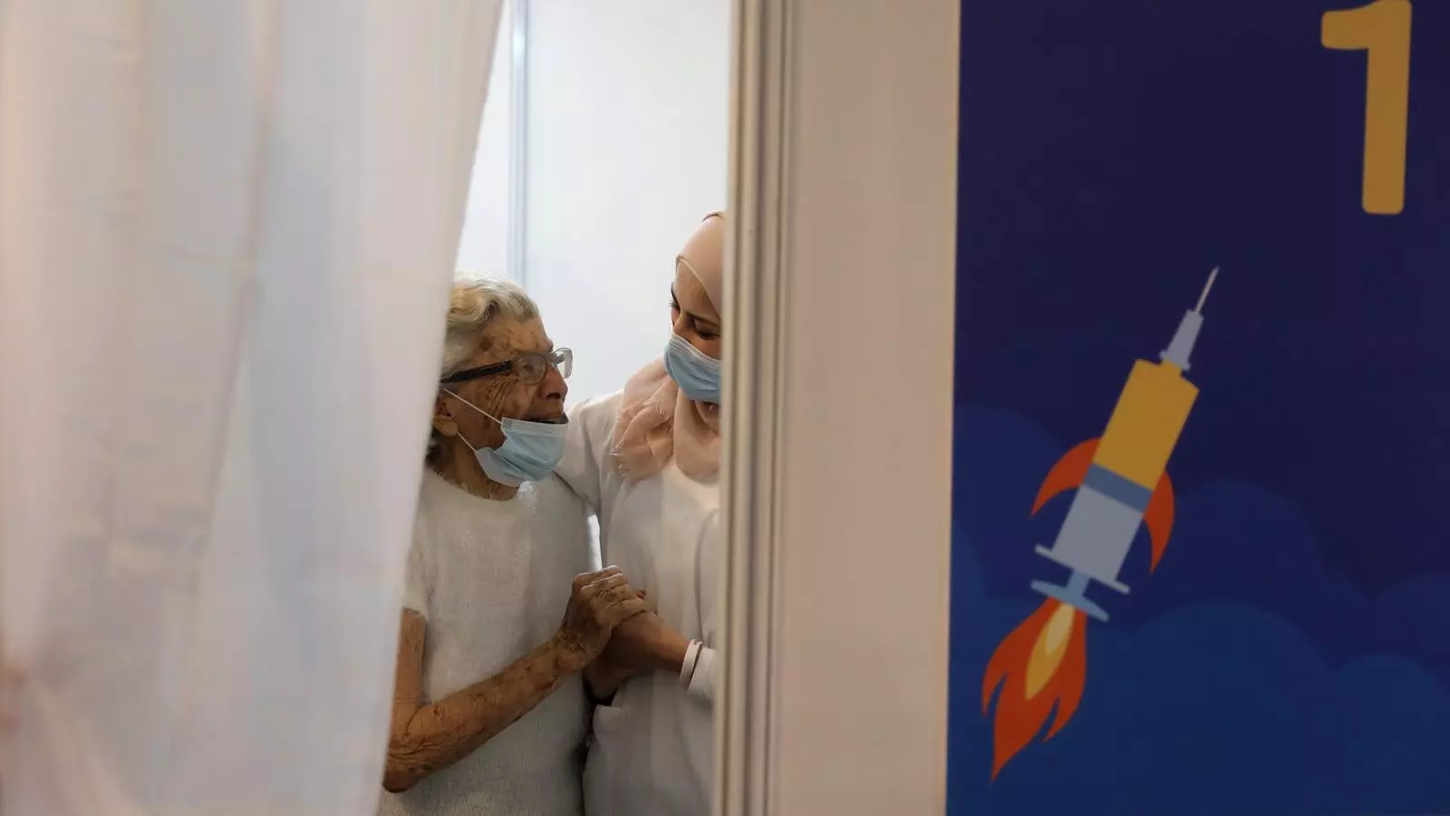 Una dona gran abraça a una infermera israeliana després de rebre la vacuna contra en coronavirus en el nou centre de vacunacions municipals de Tel Aviv