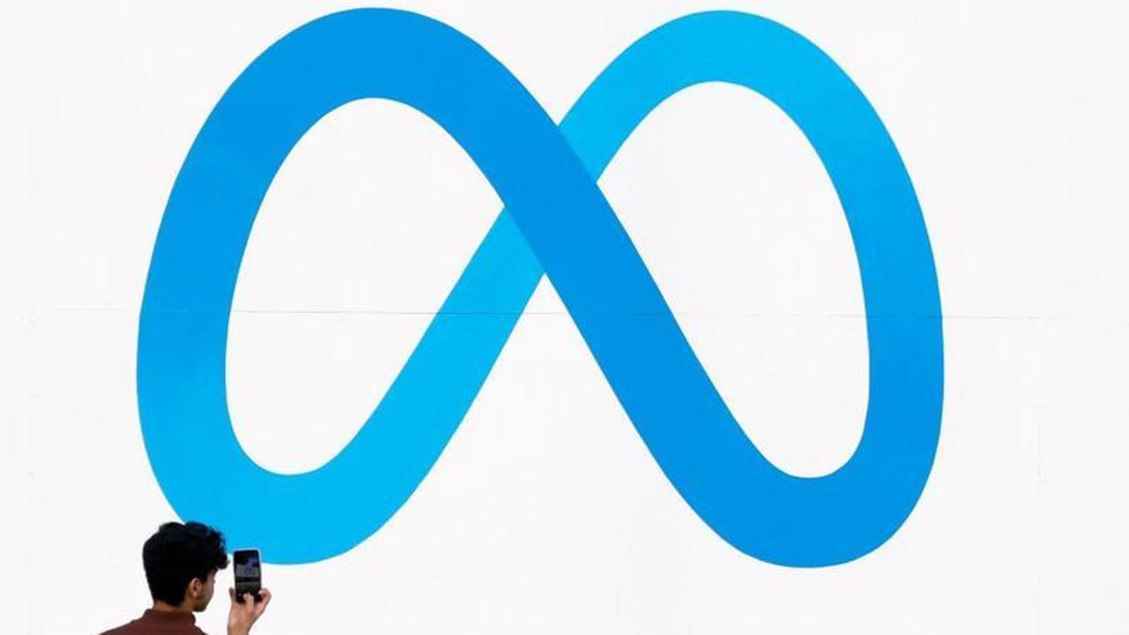 Una persona fotografía el logo de Meta en la sede de Menlo Park, California.