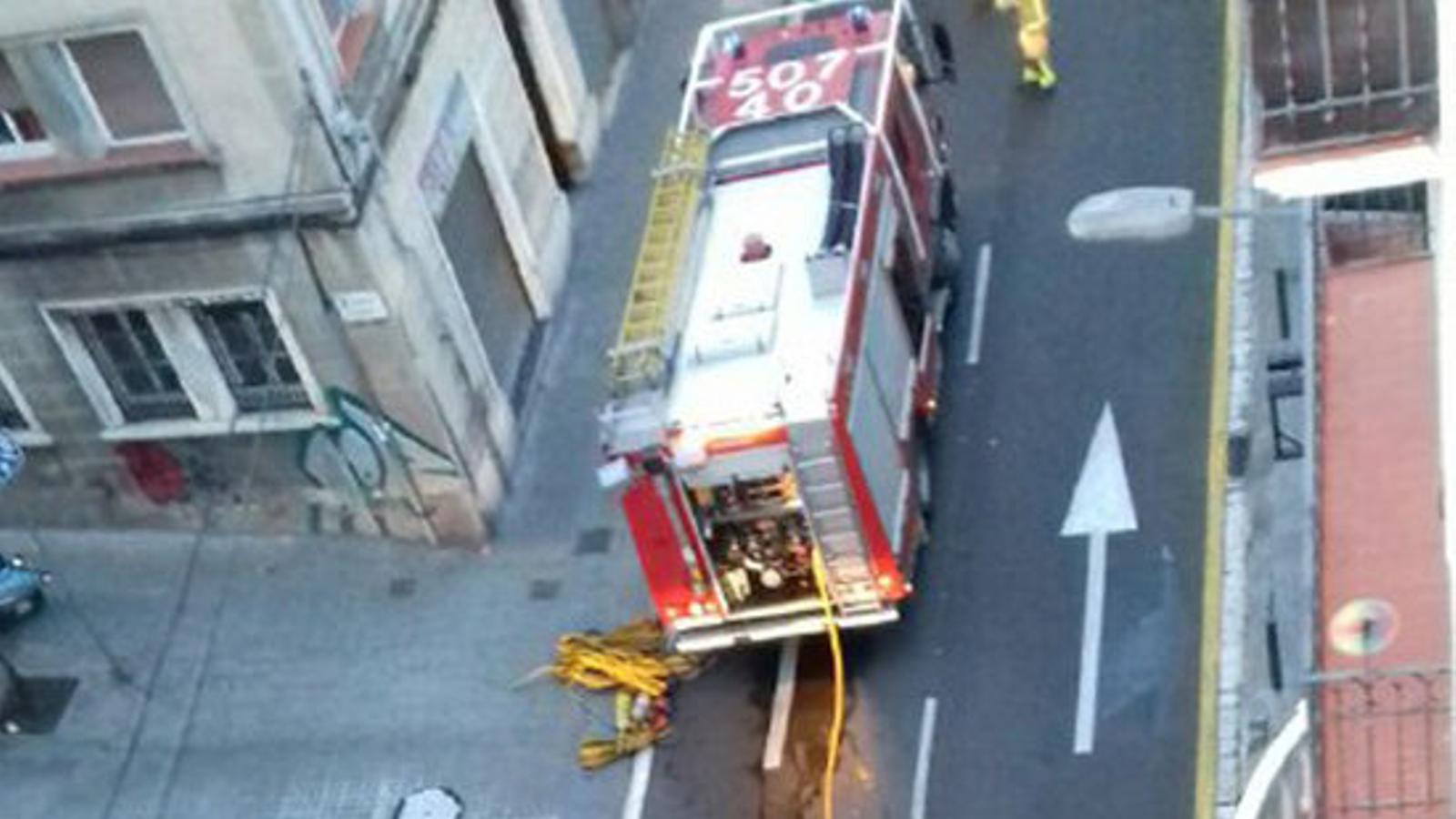 Dos camions dels Bombers treballant en l'incendi en un pis a l'Hospitalet de Llobregat