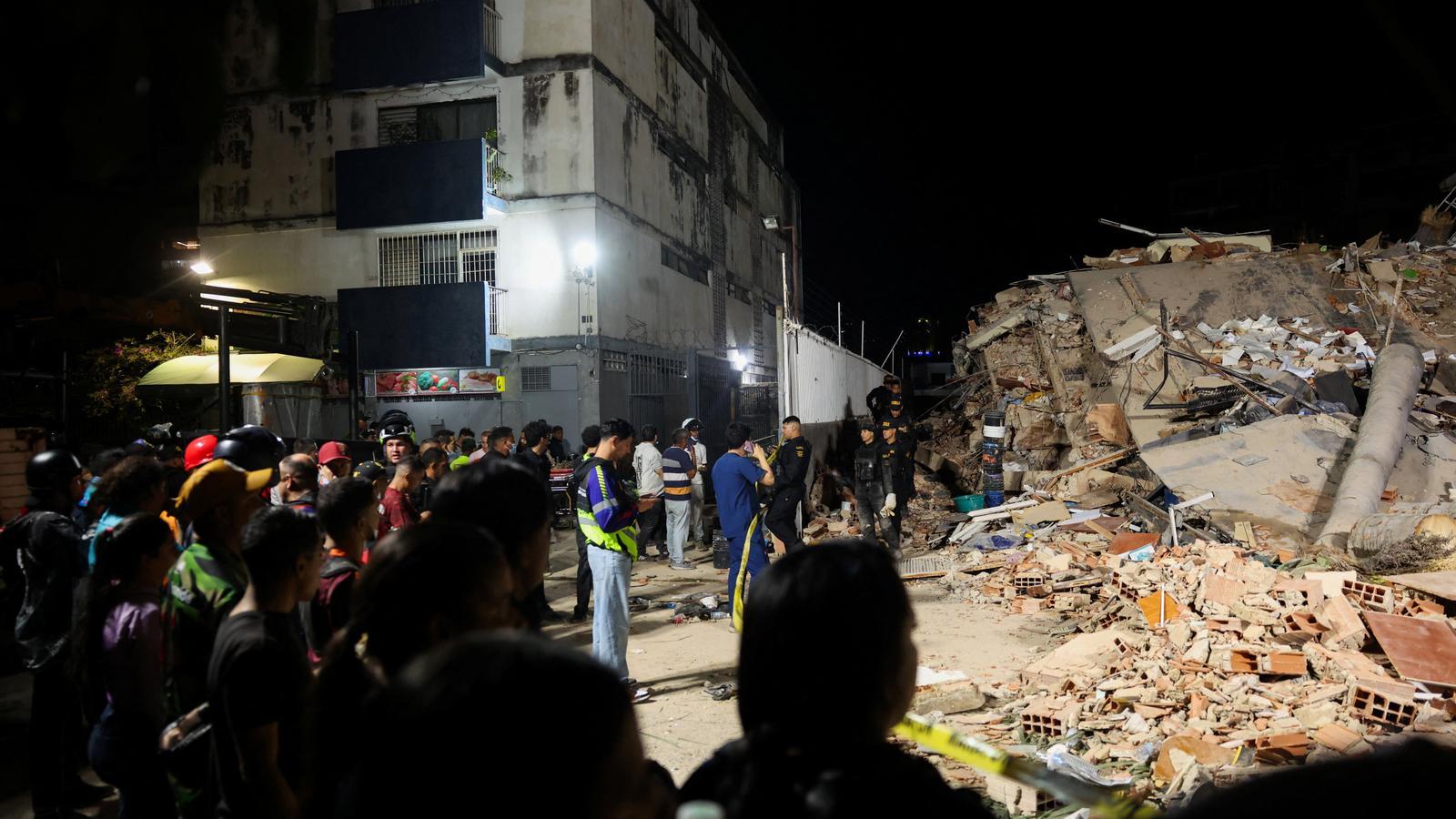 Several people observe a building collapsed by the earthquake in Caracas, Venezuela.