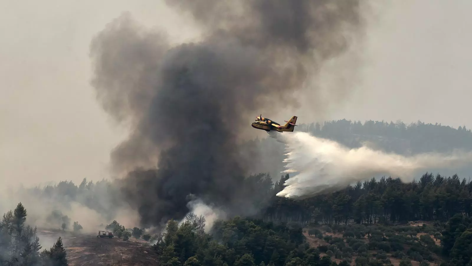 Els bombers llancen aigua des d'un helicòpter sobre el foc que crema al nord de l'illa d'Evia, prop d'Atenes.
