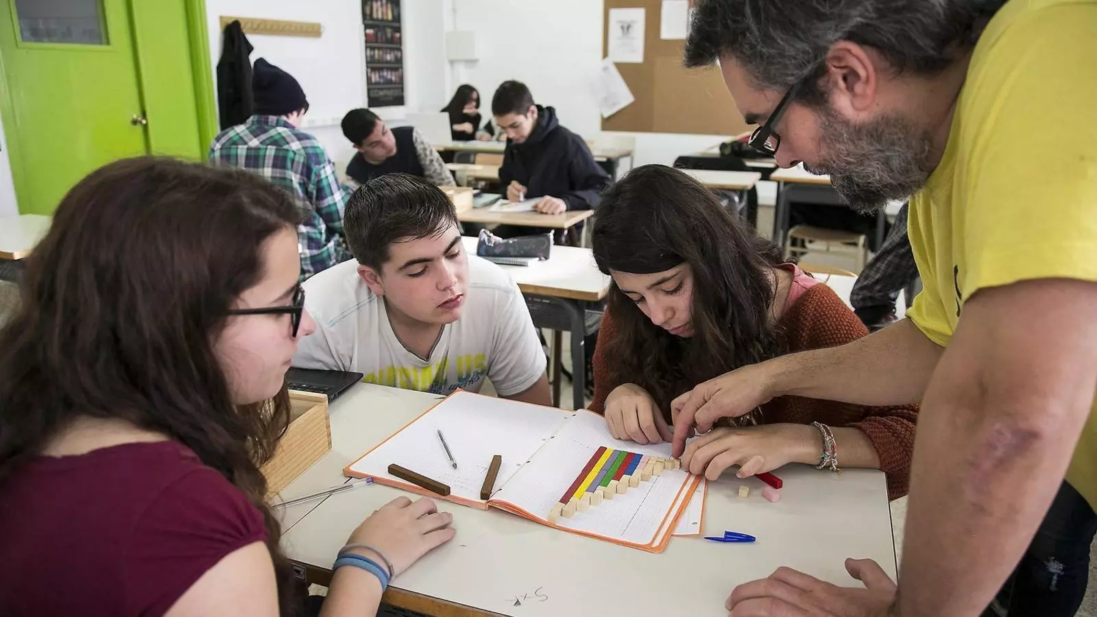 Un professor ajuda un grup d'alumnes