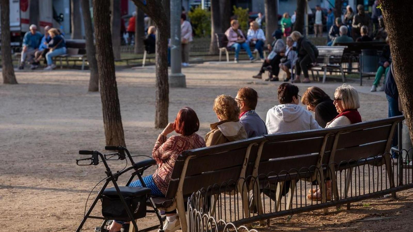 A group of elderly people sitting on a bench, in Cornellà.