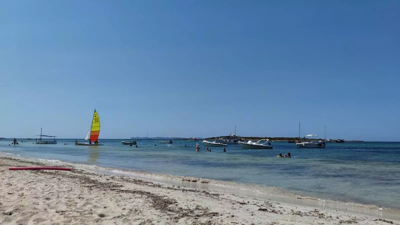 Una desena de barques fondegen a la platja del Carbó a principi del mes d'agost.