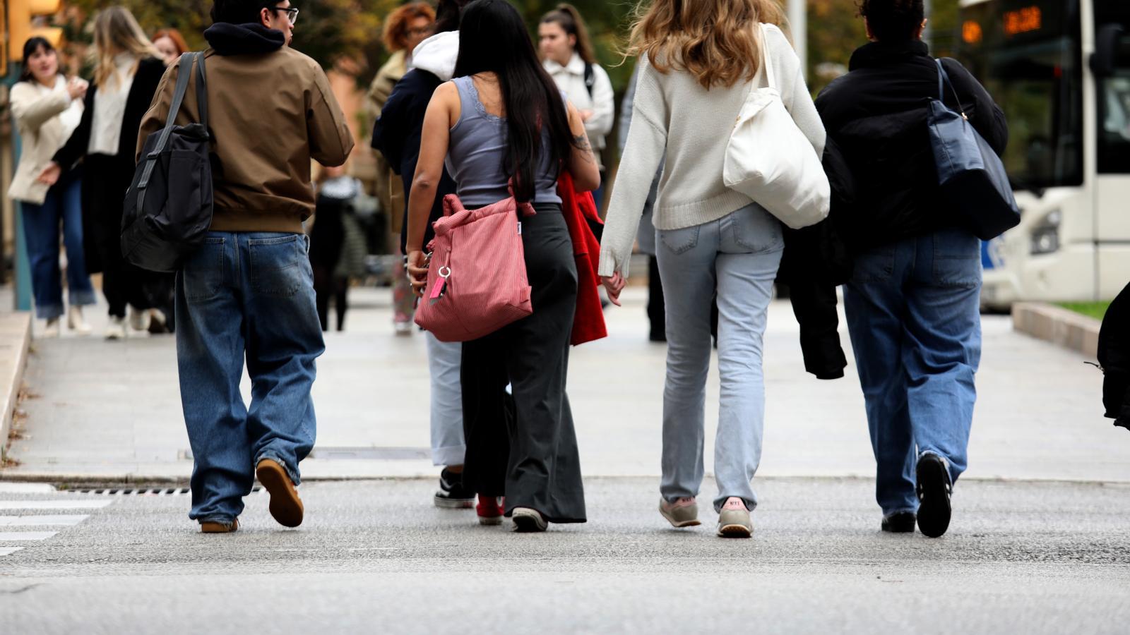 Junge Leute gehen durch die Innenstadt von Palma.