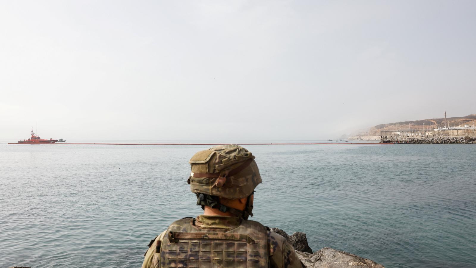 A Spanish soldier patrols the waters of Ceuta, a European border.