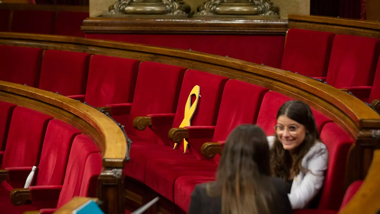 L'escó buit del diputat de JxCat Lluís Puig, amb un llaç groc, al Parlament de Catalunya