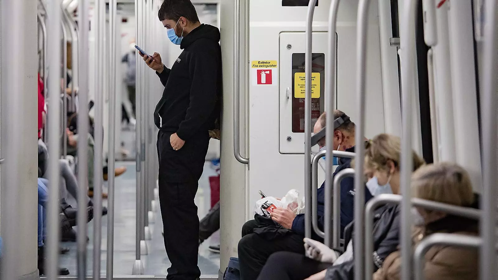 Usuaris amb mascareta viatjant al metro de Barcelona.