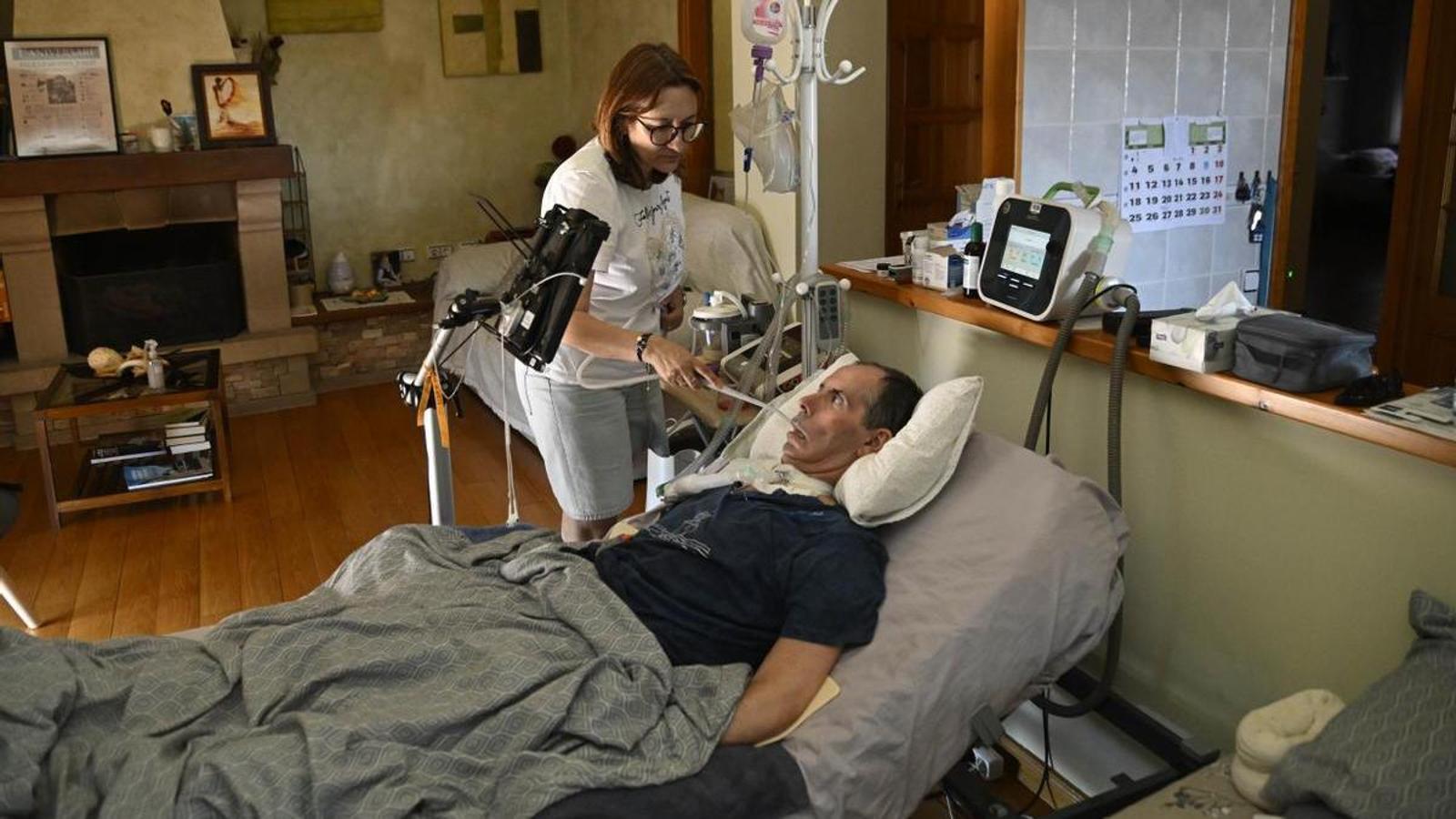 Carme Piqué attending to her husband Josep Culleré, ill with ALS, at their home in Belianes.