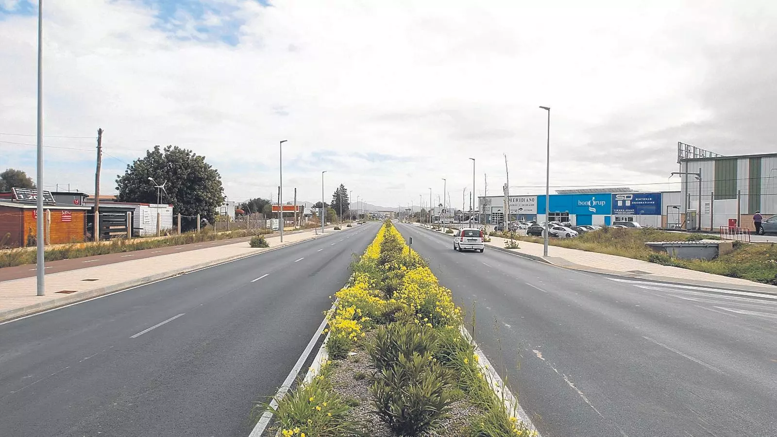 La ronda que entra a Campos, on, a banda i banda, hi ha allò que se suposa que és un polígon industrial. L’existència d’aquest polígon industrial és una part dels arguments que se suposa que justifiquen la construcció de l’autopista