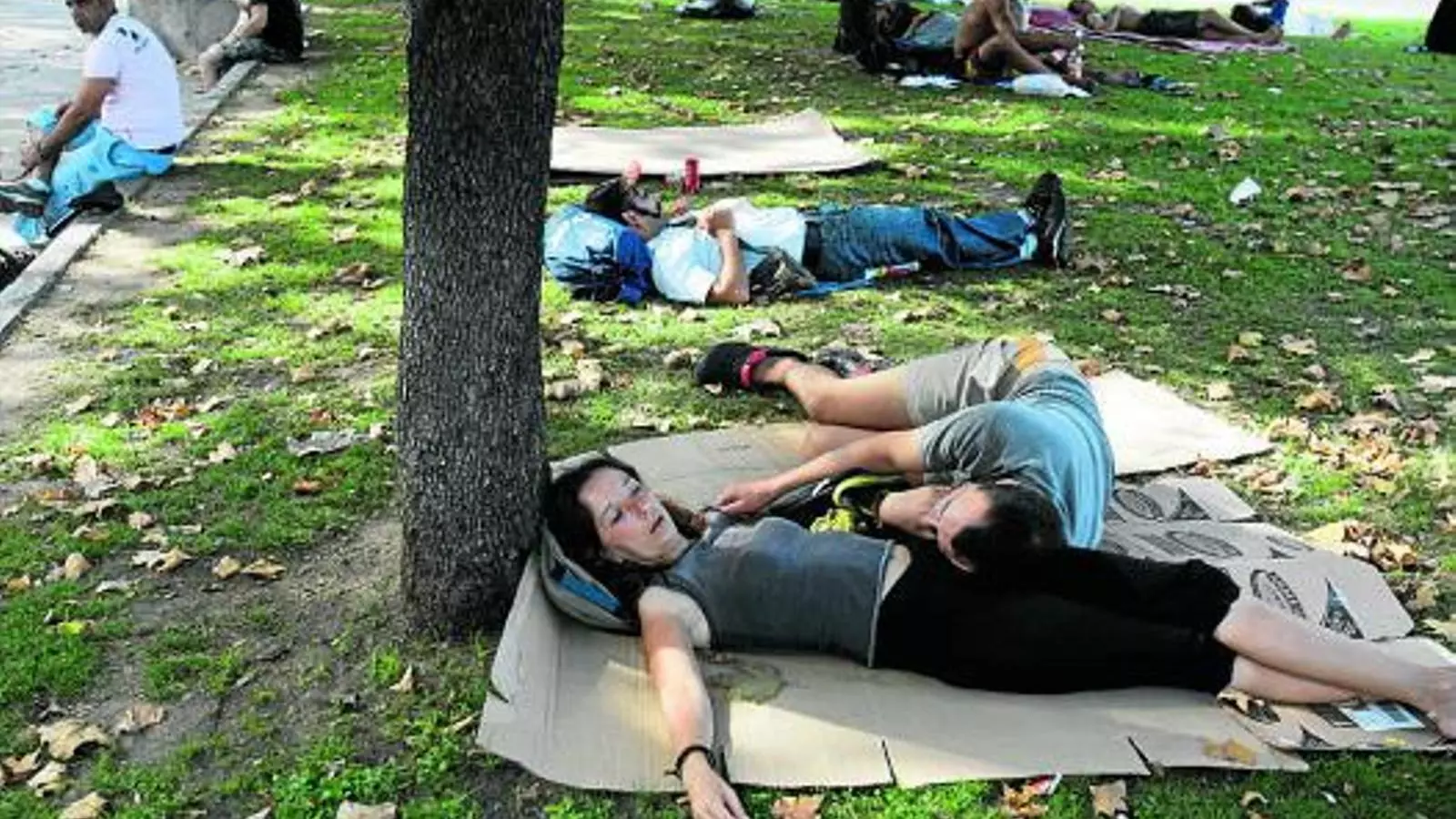 Diversos turistes es protegeixen, en un parc de Barcelona, del sol i les altes temperatures registrades a Catalunya durant l'onada de calor del 2009.
