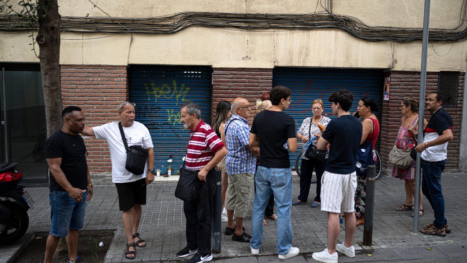 Vecinos de Hospitalet lamentan la muerte de Javi delante de su zapatería.