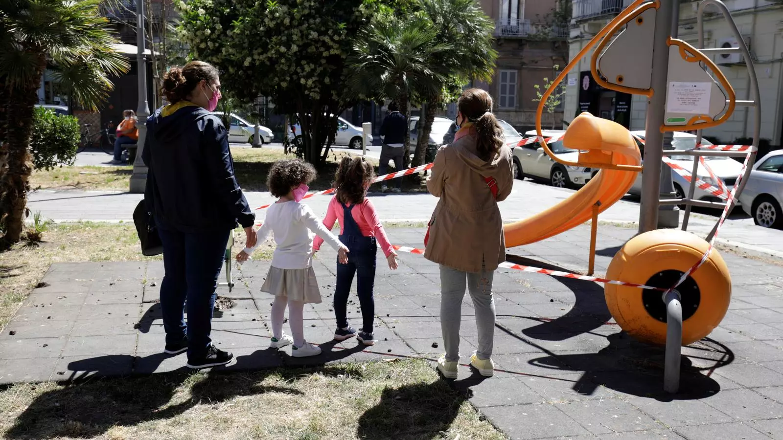 Una dona i les seves filles caminant per un carrer de Catània, a Itàlia