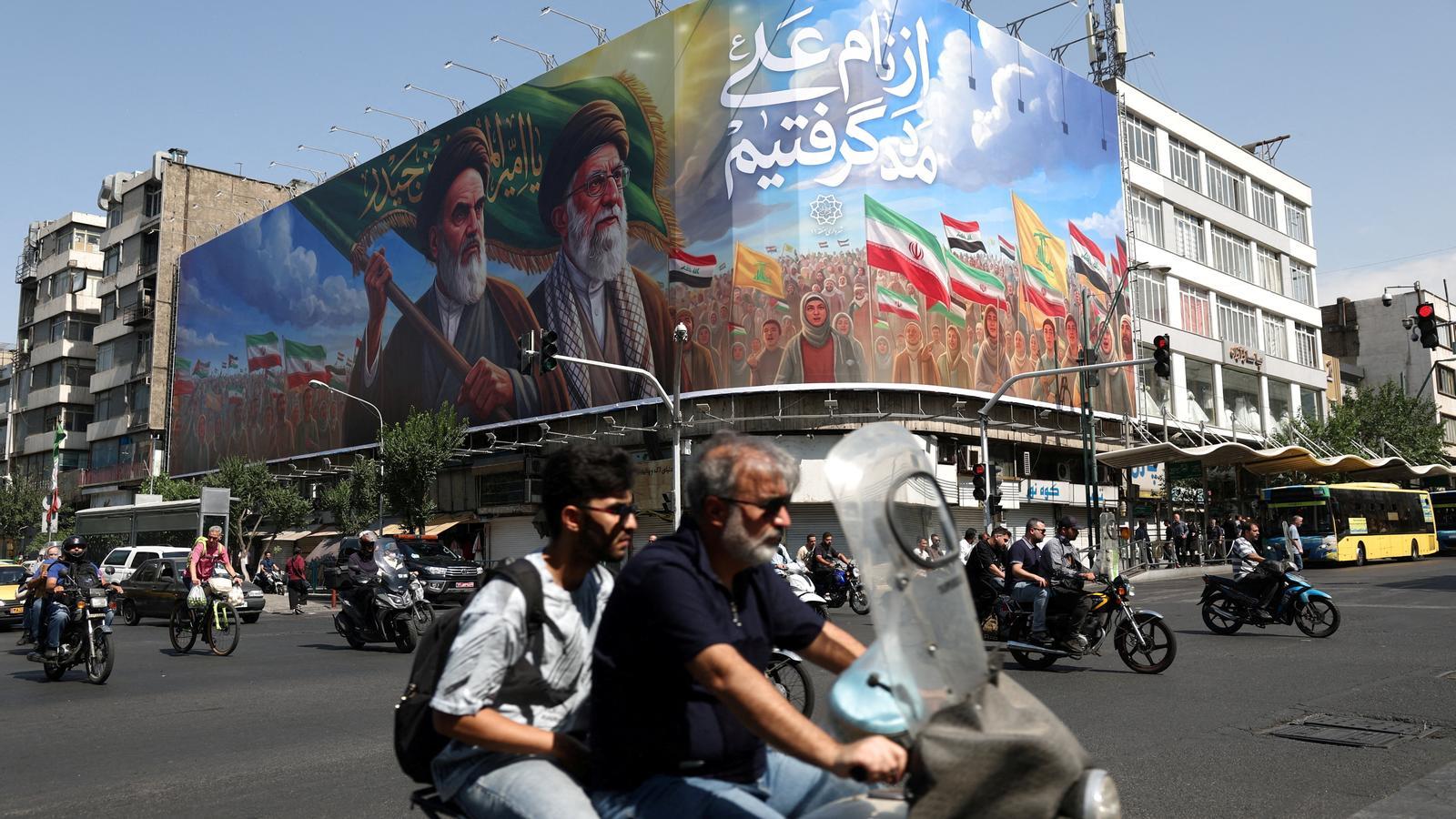 A billboard with the image of the deceased supreme leaders of Iran, Ruhollah Khomeini and Ali Khamenei, on a street in Tehran.