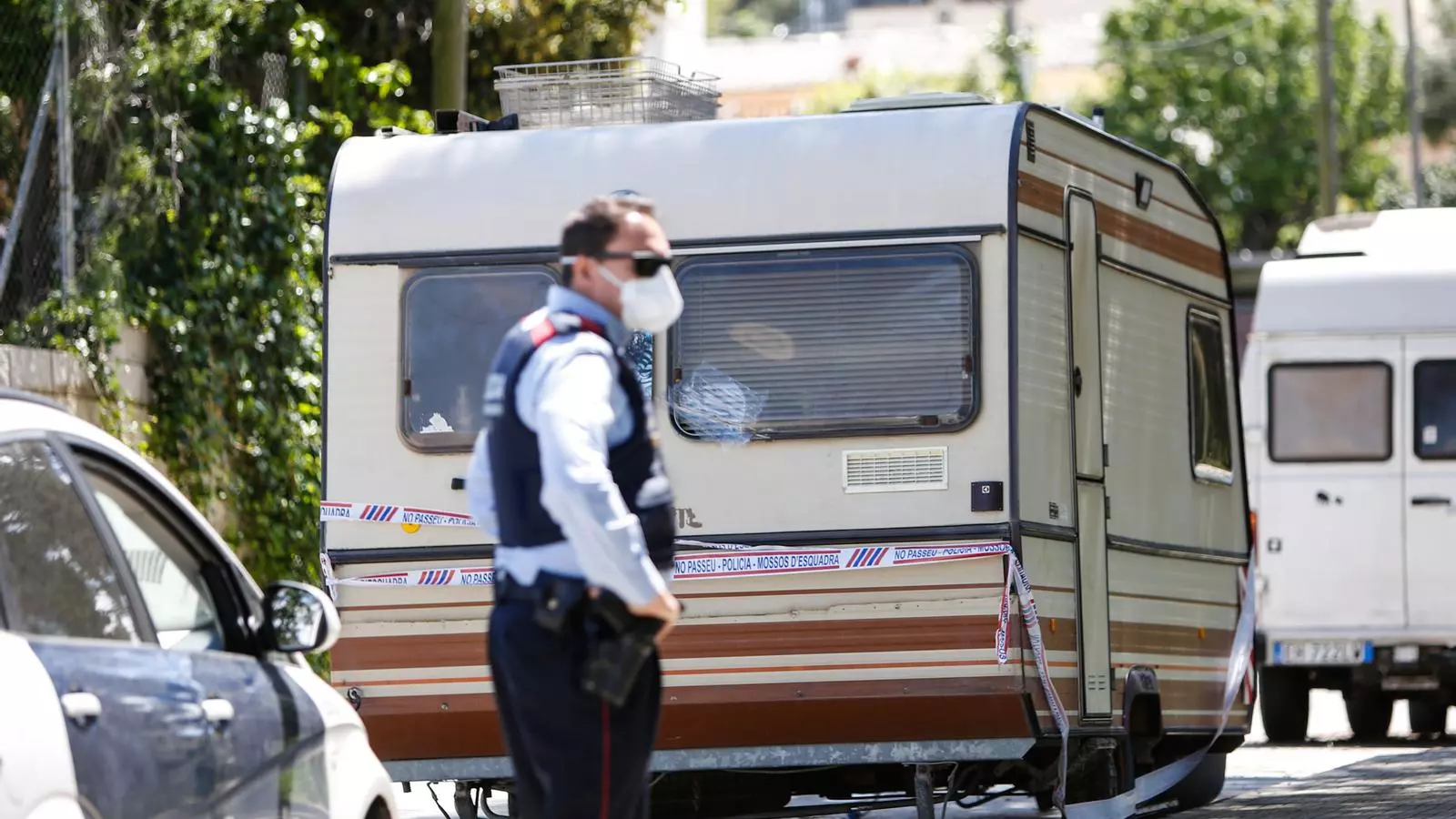 Un agent dels Mossos, davant la caravana precintada del presumpte assassí, a Les Planes