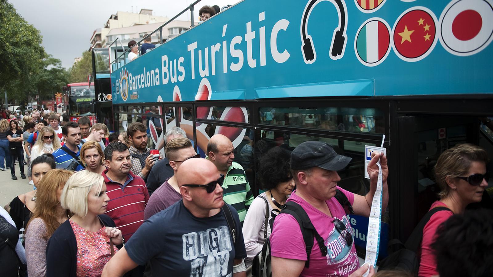 A group of tourists wait to board the tourist bus