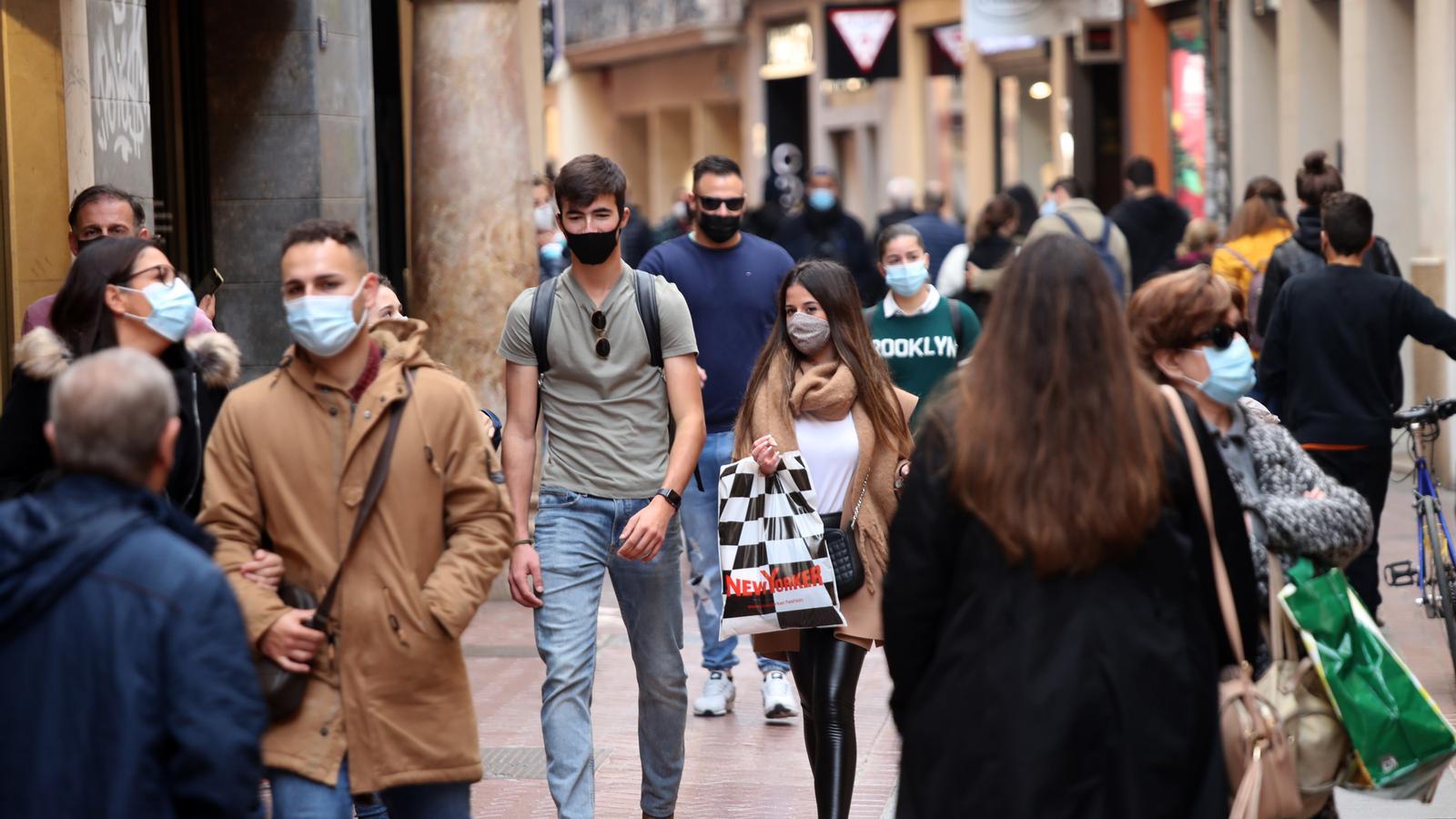 Gent per Palma caminant amb mascareta.