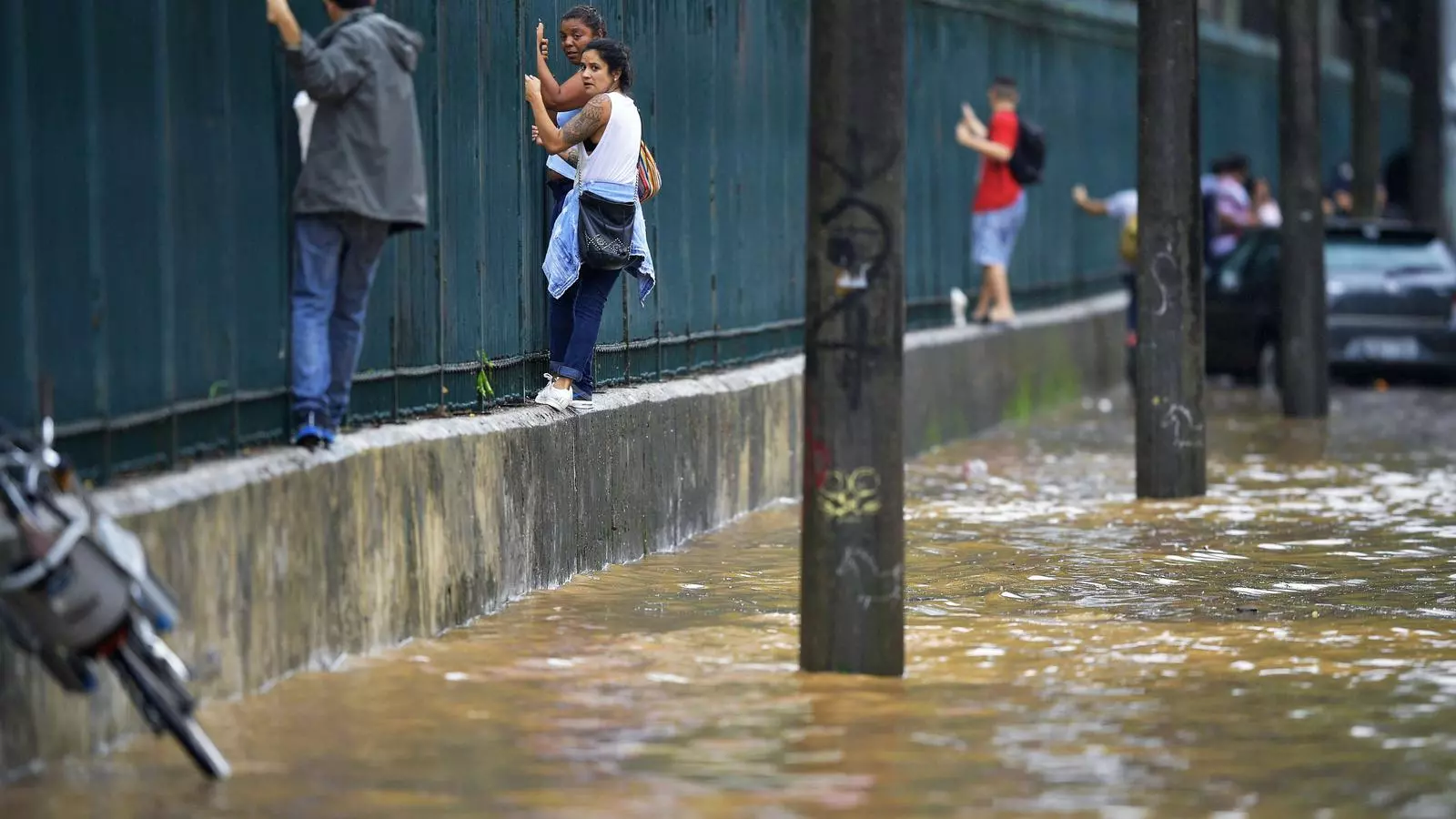 Diverses persones busquen un lloc elevat per protegir-se de les inundacions a Rio de Janeiro.