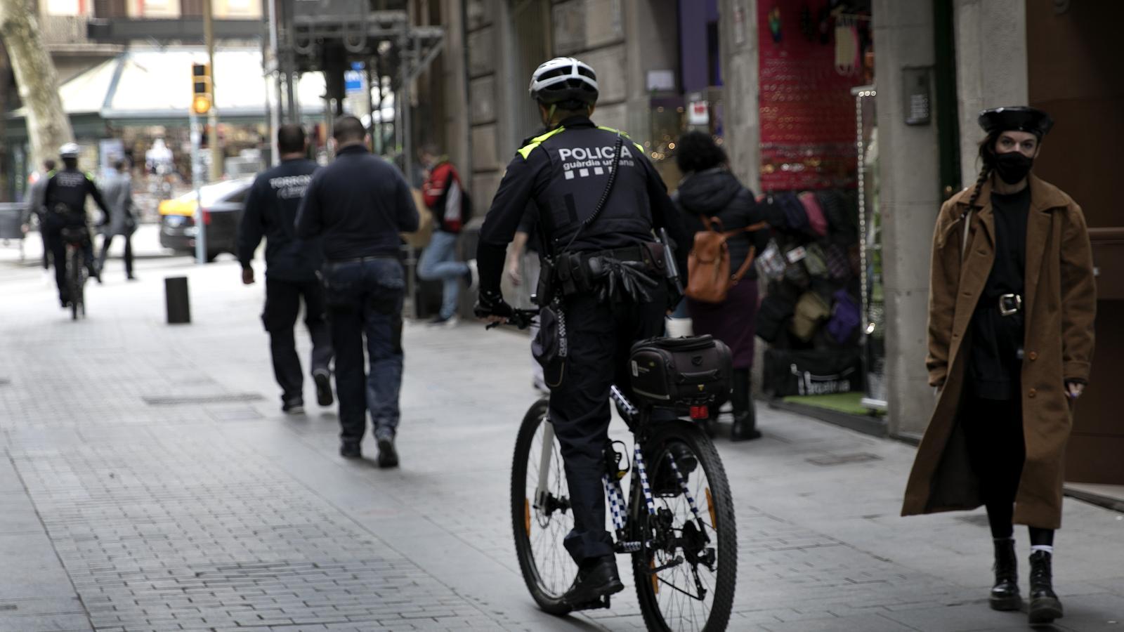 A Guardia Urbana agent patrols by bicycle through the center of Barcelona, in an archive image.