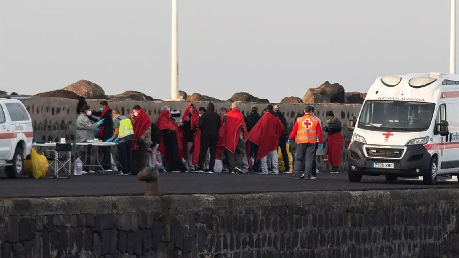 Els 23 rescatats d'una pastera rebent la primera assistència sanitària, al port d'Arrecife de Lanzarote