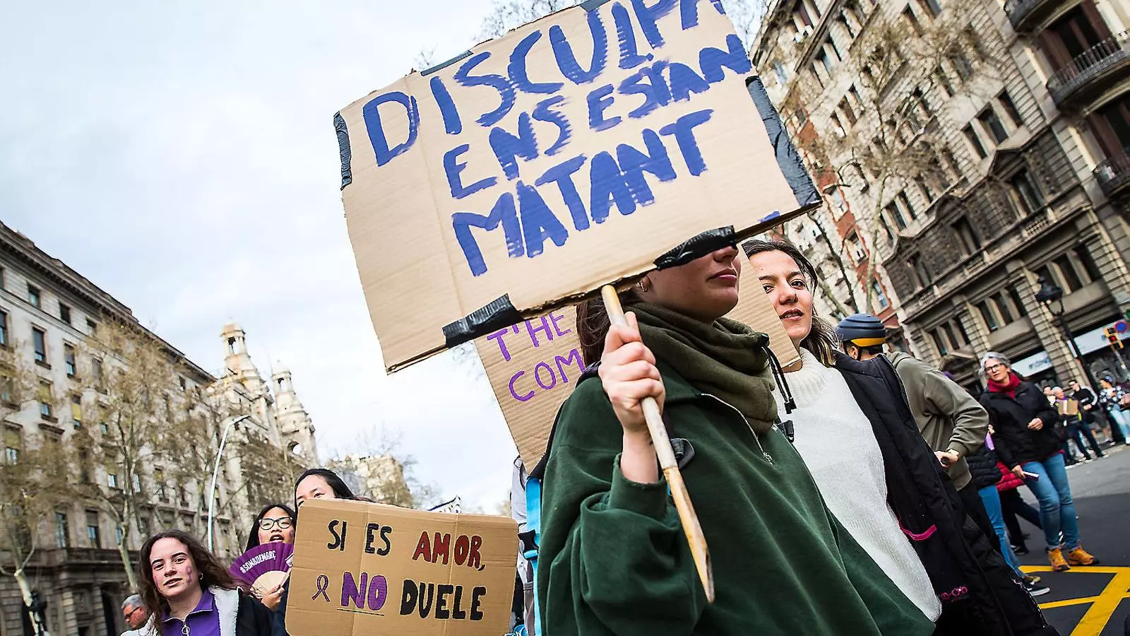 Manifestants el 8-M a Barcelona ensenyant cartells contra la violència masclista.