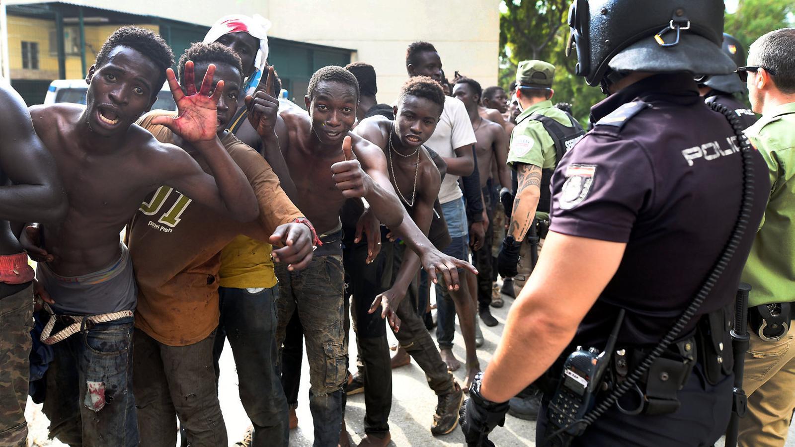 Cinc migrants celebren el seu ingrés al Centre d’Estada Temporal de Ceuta després d’aconseguir saltar la tanca.