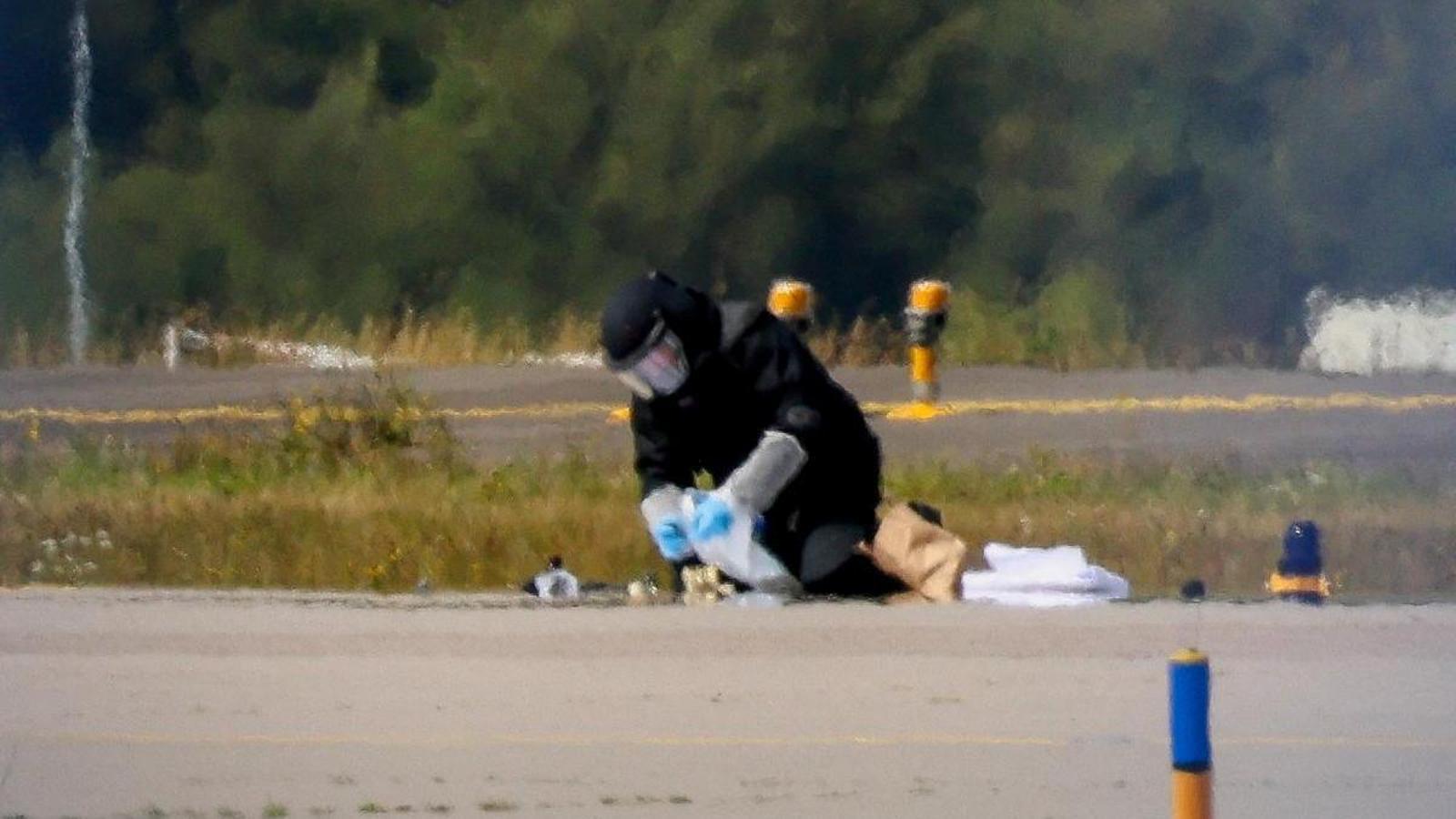 Un agente de policía con equipo de protección trabaja en el aeropuerto de Leipzig/Halle tras un incidente con un dron cerca de la pista.
