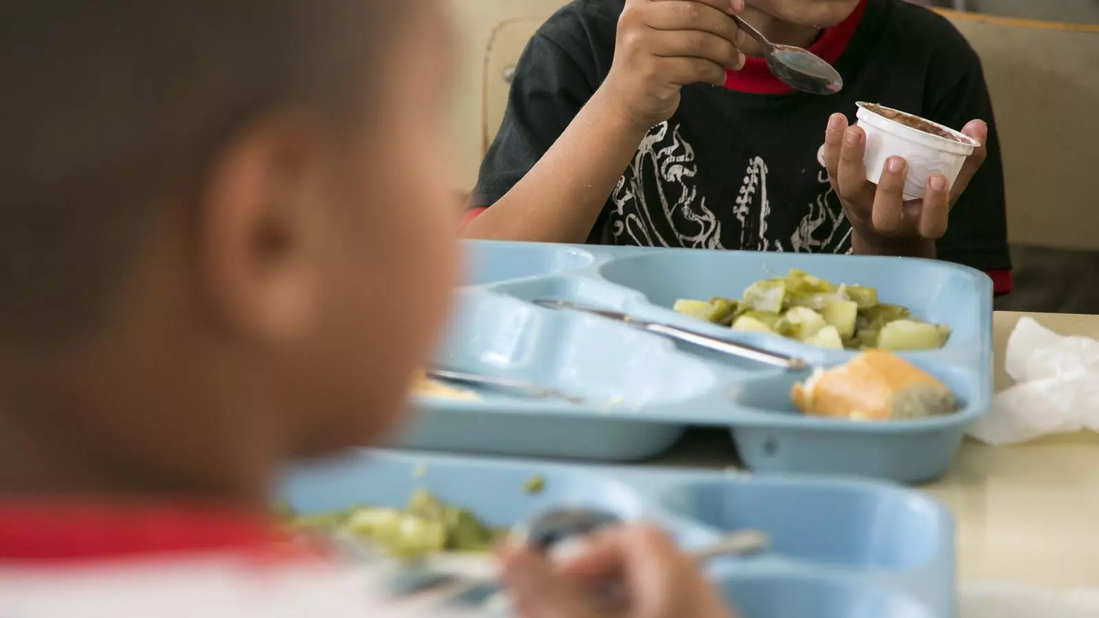 Unos niños comiendo al comedor escolar